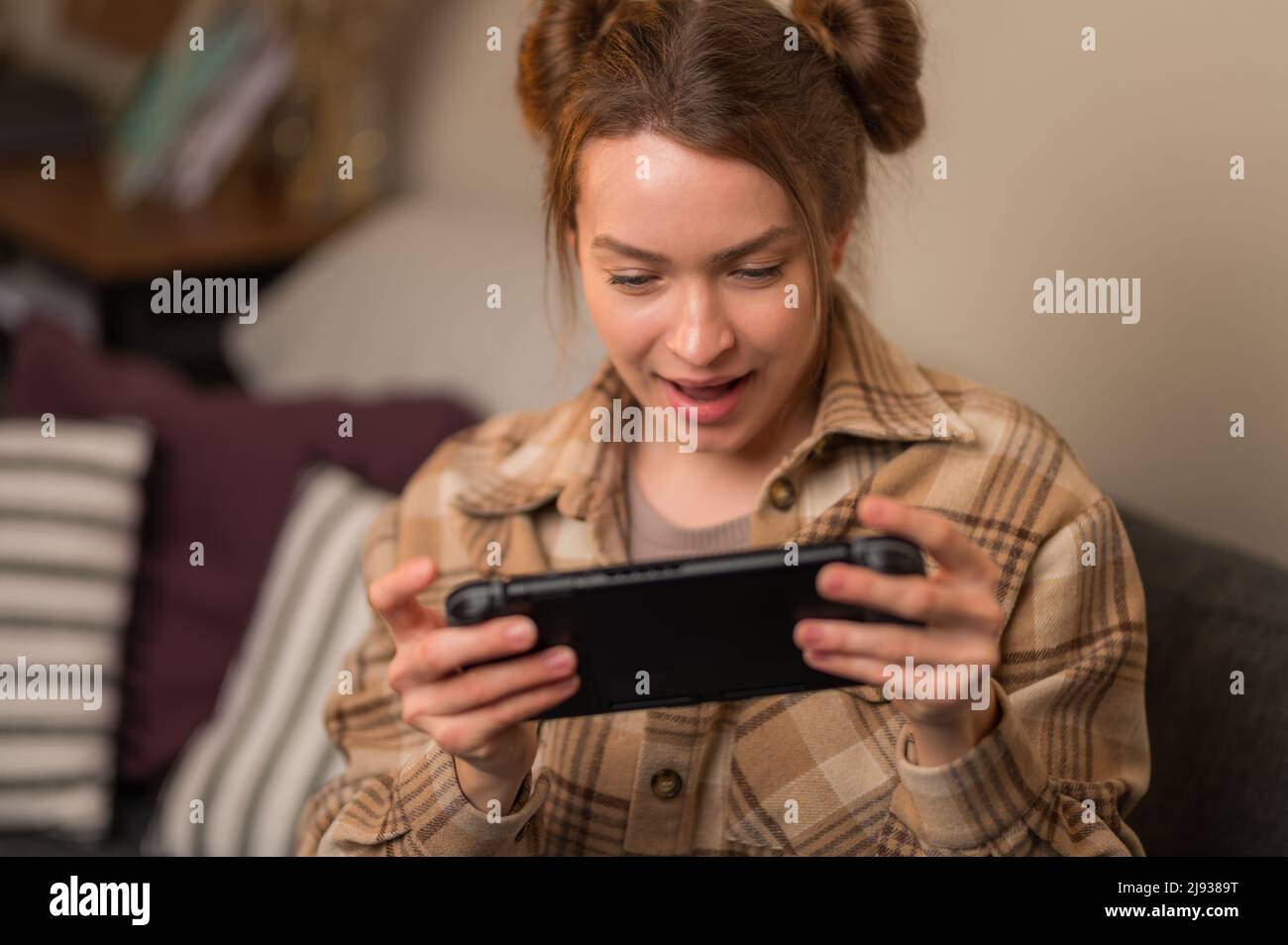 Mädchen Gamer spielt begeistert ein Videospiel mit Freunden online. Spaß, Hobby, Kommunikation, Jugendkultur, neue Funktechnologien, Virtuelle Reali Stockfoto