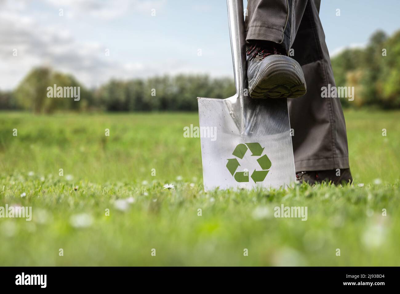 Spatenstich mit einem Nachhaltigkeitssymbol auf dem Spaten Stockfoto