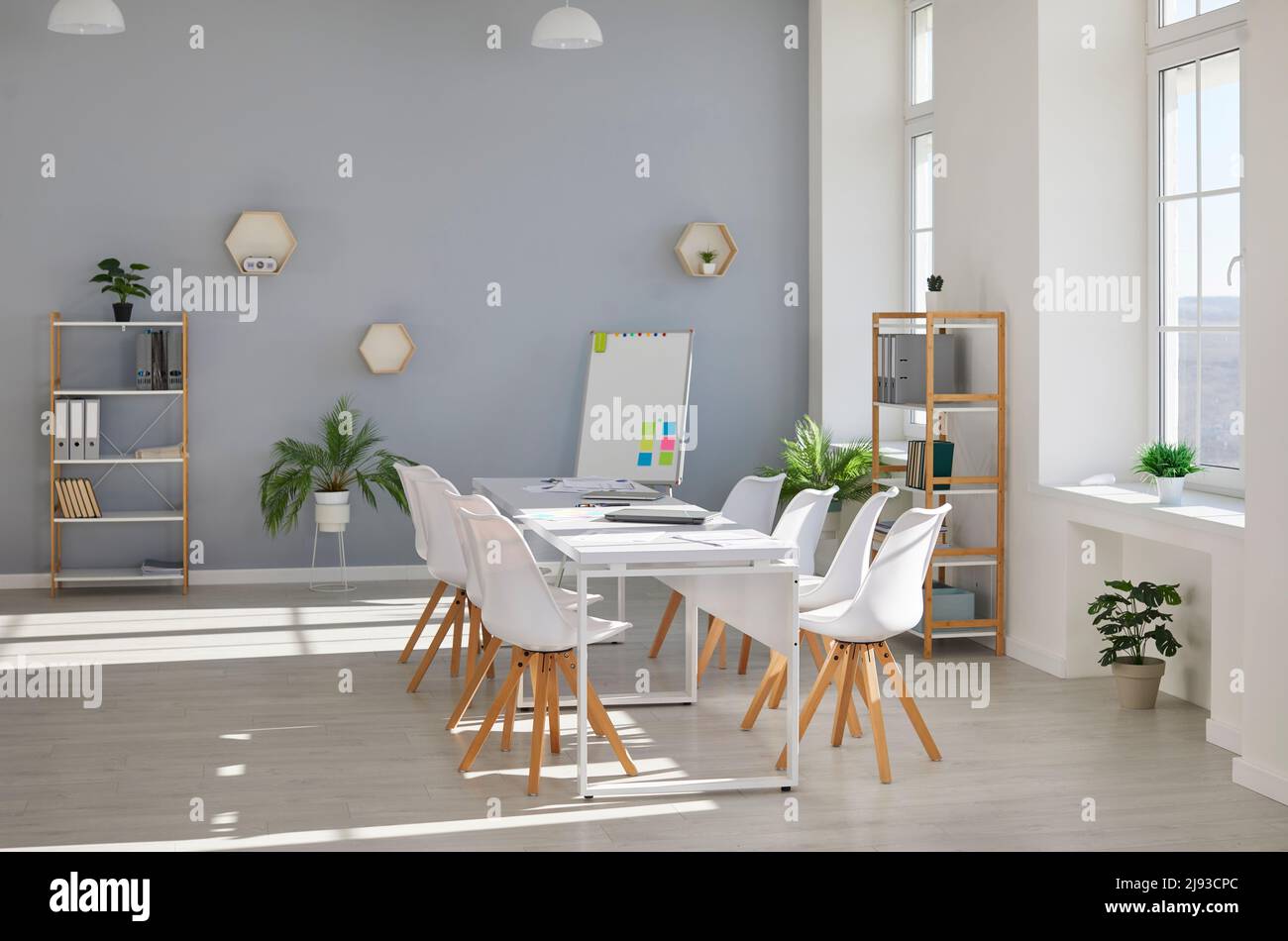 Modernes Bürointerieur mit Konferenztisch, Stühlen, Whiteboard, Regalen und Zimmerpflanzen Stockfoto