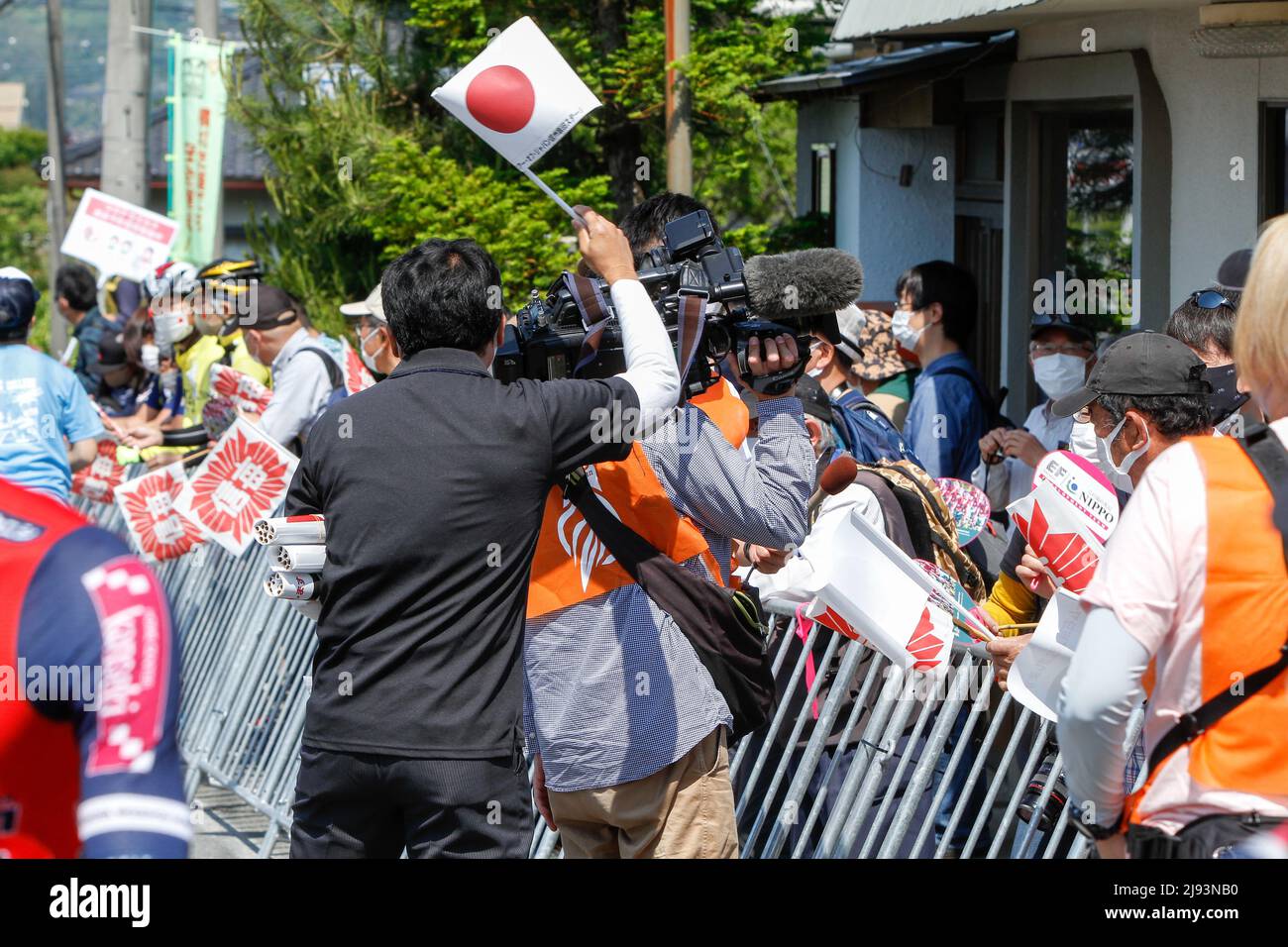 iida, nagano, japan, 2022/19/05 , Mitglied des Teams, das Flaggen verteilt, um auf der professionellen Radtour durch Japan im Frühjahr in Iida zu feiern Stockfoto