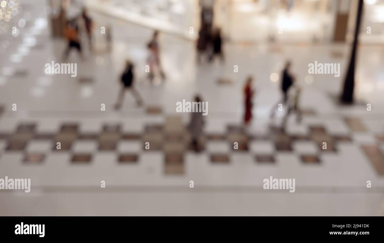 Verschwommenes Bild von Menschen, die in der Halle des Einkaufszentrums gehen. Hintergrundbild. Stockfoto
