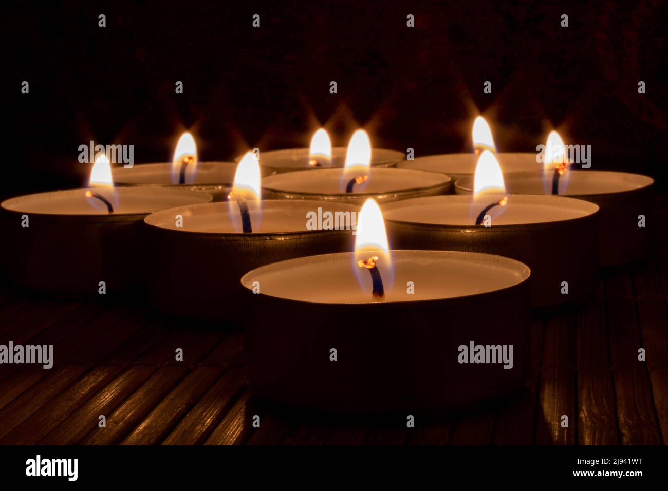 Nahaufnahme von beleuchteten Kerzen auf Holztisch. Konzept für Beileid, Hoffnung, Romantik Stockfoto