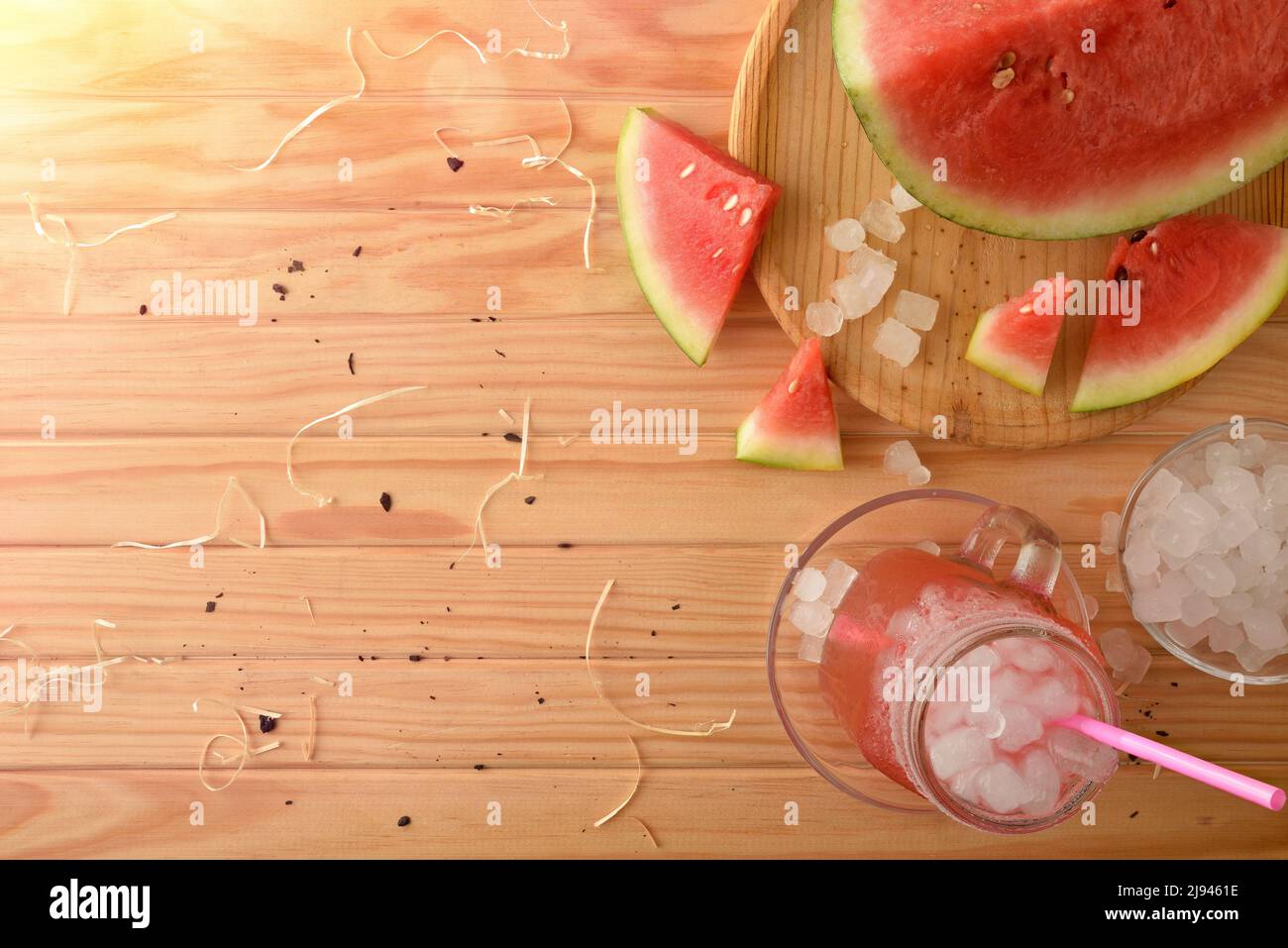 Glas mit natürlicher Wassermelone Getränk mit Eis auf einem Holztisch mit Früchten um. Draufsicht. Horizontale Zusammensetzung. Stockfoto