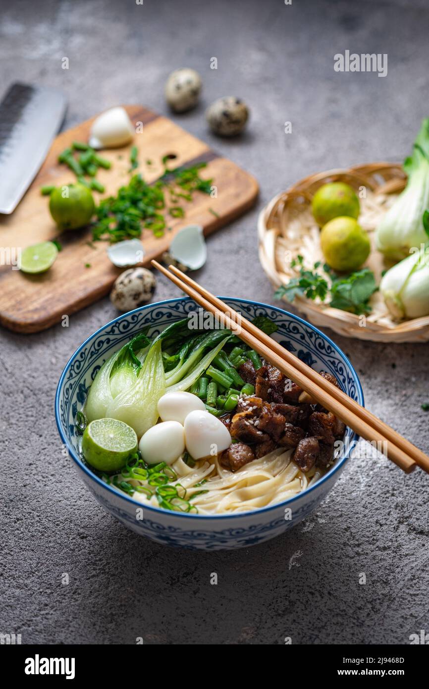 Traditionelle asiatische Nudelsuppe mit Bok Choi und Huhn in einer Keramikschale. Stockfoto