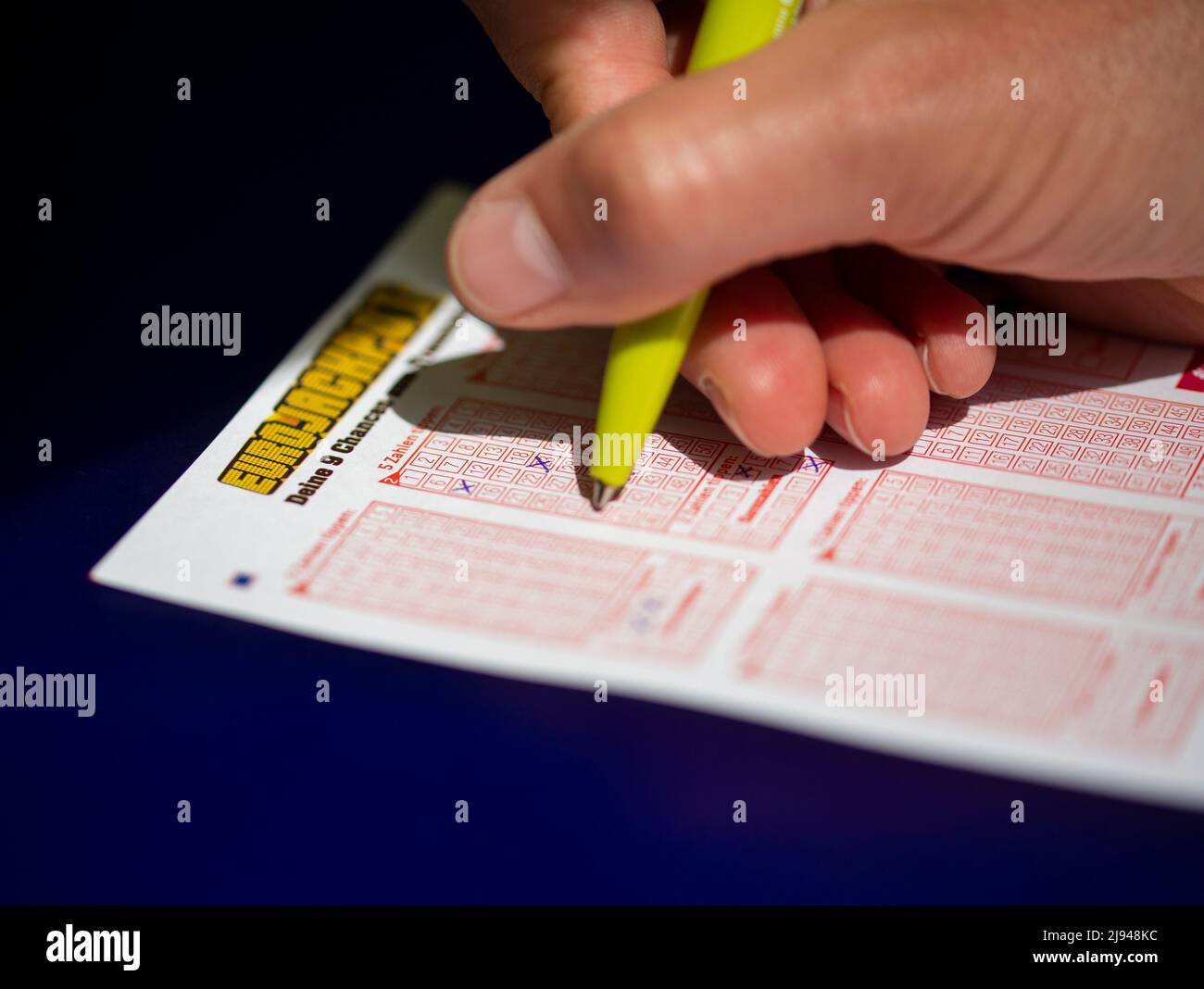 Köln, Deutschland. 20.. Mai 2022. ABBILDUNG - Ein Mann füllt eine Eurojackpot Lotterie-Ticket. Eurojackpot-Rekord möglich - erstmals über 100 Millionen Euro. In Deutschland liegt der bisherige Rekord bei 90 Millionen Euro. Aufgrund der neuen Obergrenze im Eurojackpot von 120 Millionen Euro können Lotteriespieler höhere Gewinnbeträge sammeln. Am Freitag stehen 106 Millionen Euro auf dem Spiel. Kredit: Thomas Bandeyer/dpa/Alamy Live Nachrichten Stockfoto