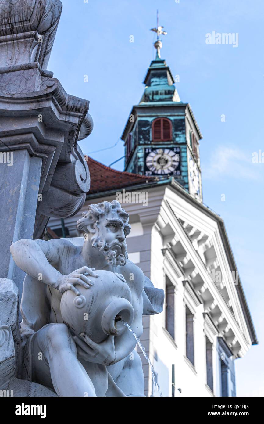 Ljubljana, Slowenien - 07.15.2021: Marmorfigur des Brunnens mit dem Stadthaus-Backgrownd in Ljubljana Stockfoto