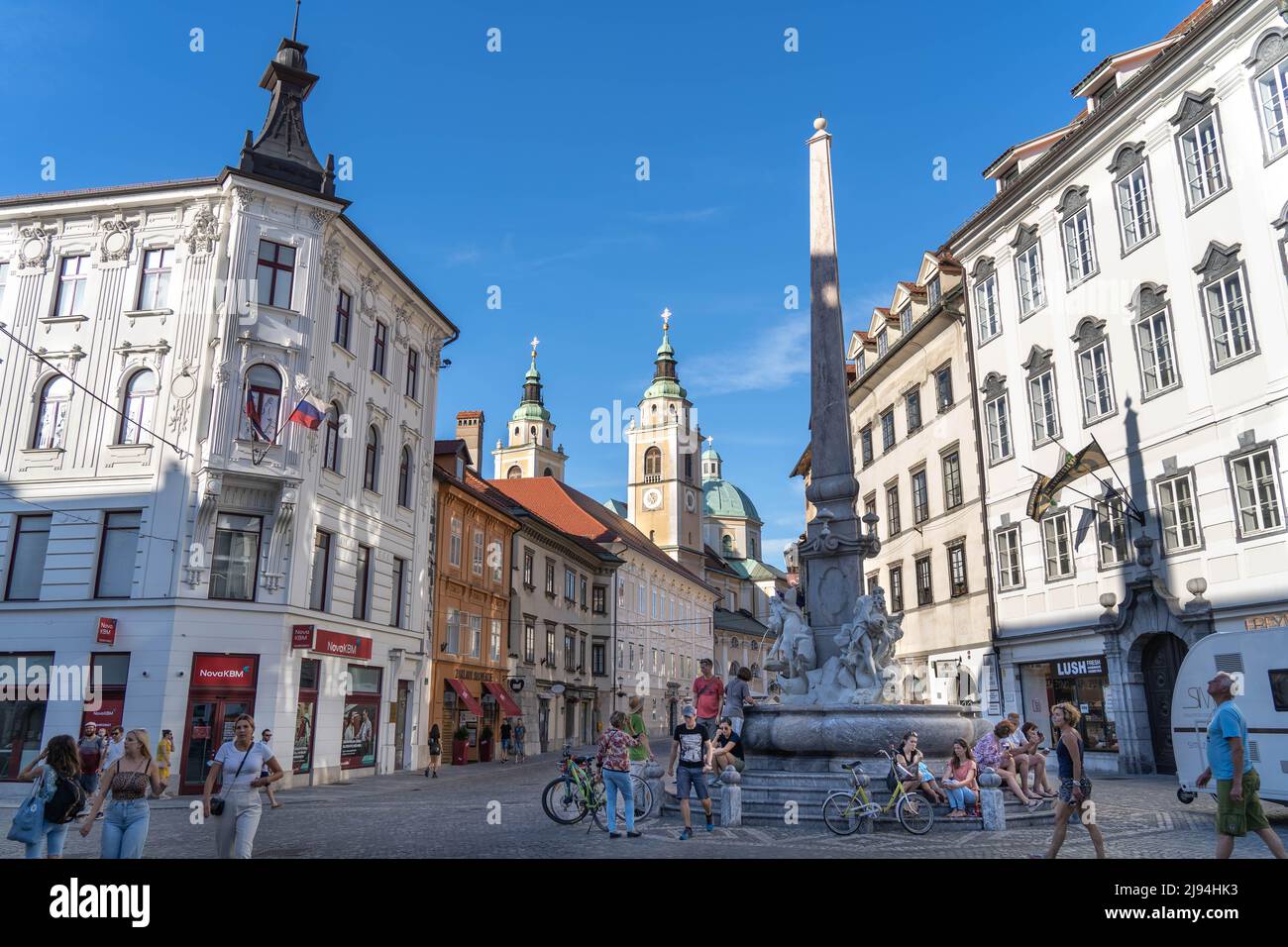 Ljubljana, Slowenien - 07.15.2021: In Ljubljana ruhen die Menschen in der Nähe des alten klassischen Brunnens mit Statuen Stockfoto