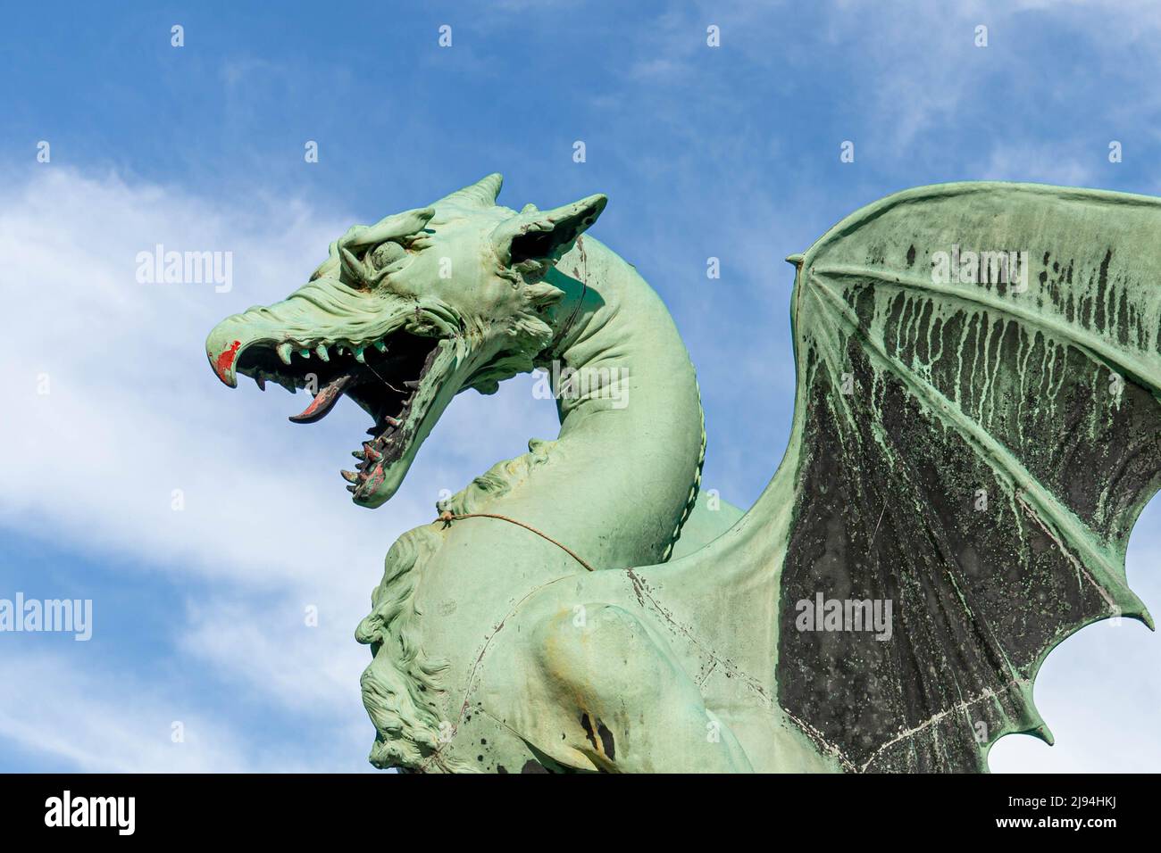 Ljubljana, Slowenien - 07.15.2021: Eine Bronzeskulptur des Drachen mit blauem Himmel, die nach links schaut Stockfoto