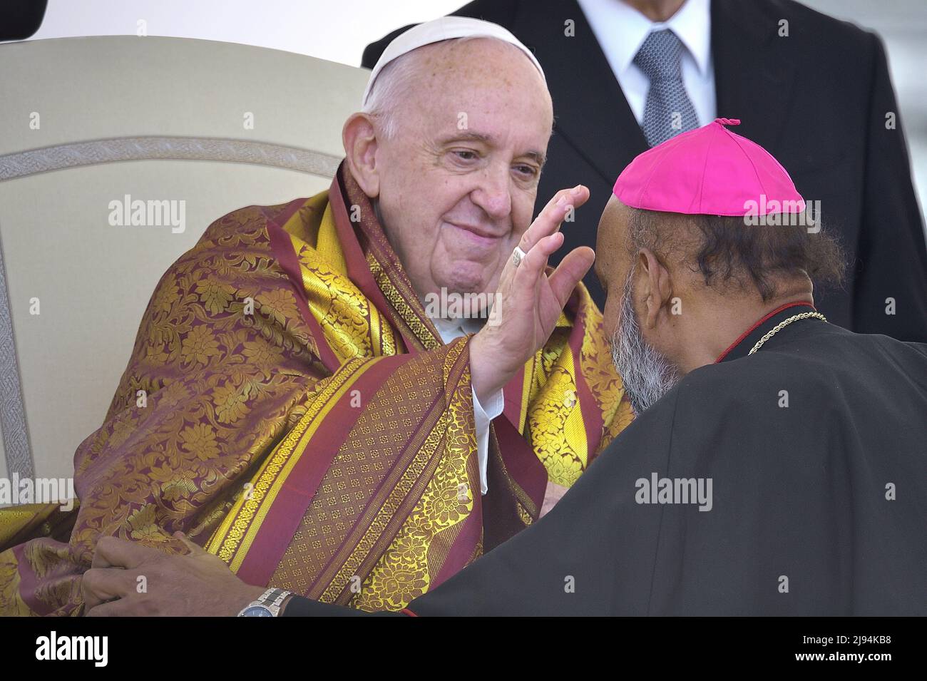 Vatikanstadt, Vatikanstadt. 18.. Mai 2022. Ein indischer Priester bedeckt die Schultern von Papst Franziskus mit einem gelben Schal, ein Symbol für Respekt und Ehre.Papst Franziskus bei einer wöchentlichen Generalaudienz auf dem Petersplatz am 18. Mai 2022 Quelle: dpa/Alamy Live News Stockfoto