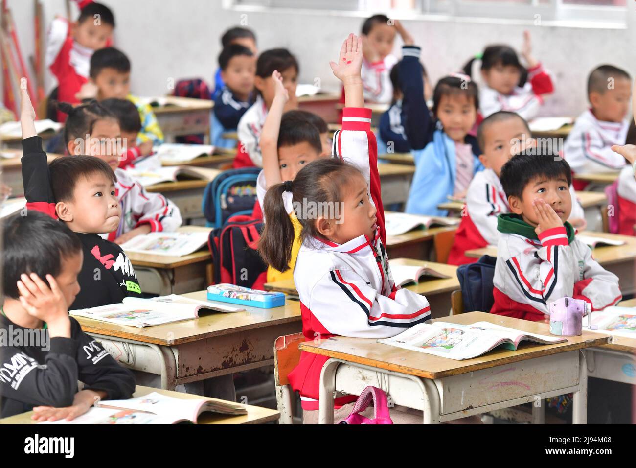 DU'AN, 20. Mai 2022 (Xinhua) -- Kinder besuchen eine Klasse in der Sanzhiyang Grundschule im Autonomen Bezirk Du'an Yao, südchinesische Autonome Region Guangxi Zhuang, 18. Mai 2022. Vor 11 Jahren wuchsen die Kinder von Sanzhiyang auf einer Diät aus gedämpftem Reis und Sojabohnen auf, einem der wenigen Dinge, die dort wachsen würden. Damals war Mangelernährung bei den Studenten üblich. Im Jahr 2011 begann ein Plan zur Verbesserung der Ernährung für Schüler in ländlichen Gebieten, der Schülern in Schulen wie Sanzhiyang nahrhafte Mahlzeiten bietet. Heute dient die gut ausgestattete Kantine der Grundschule von Sanzhiyang sorgenvoll Stockfoto