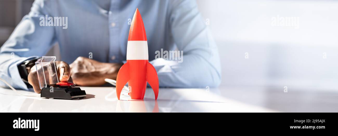 Der Geschäftsmann Hand mit Raketen durch Drücken der roten Taste Stockfoto