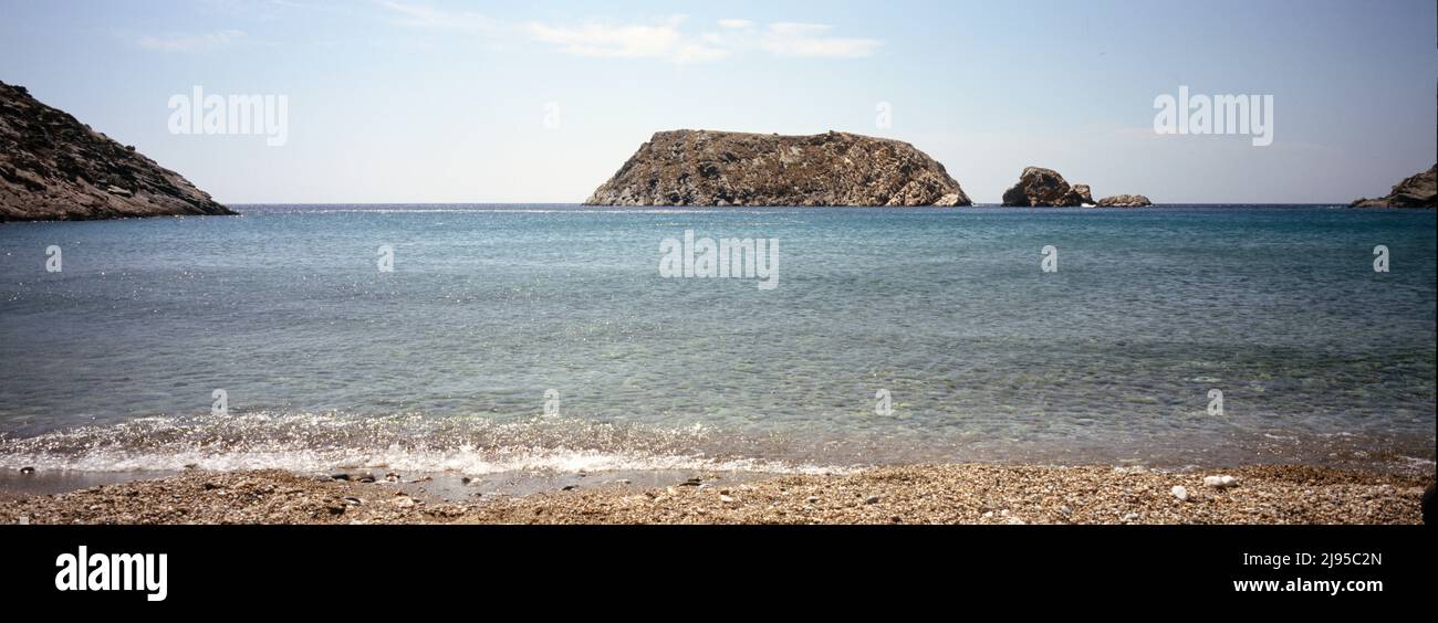 Delpfini Bucht und Strand mit Blick auf die Delfini Insel, Syros, Griechenland. Stockfoto