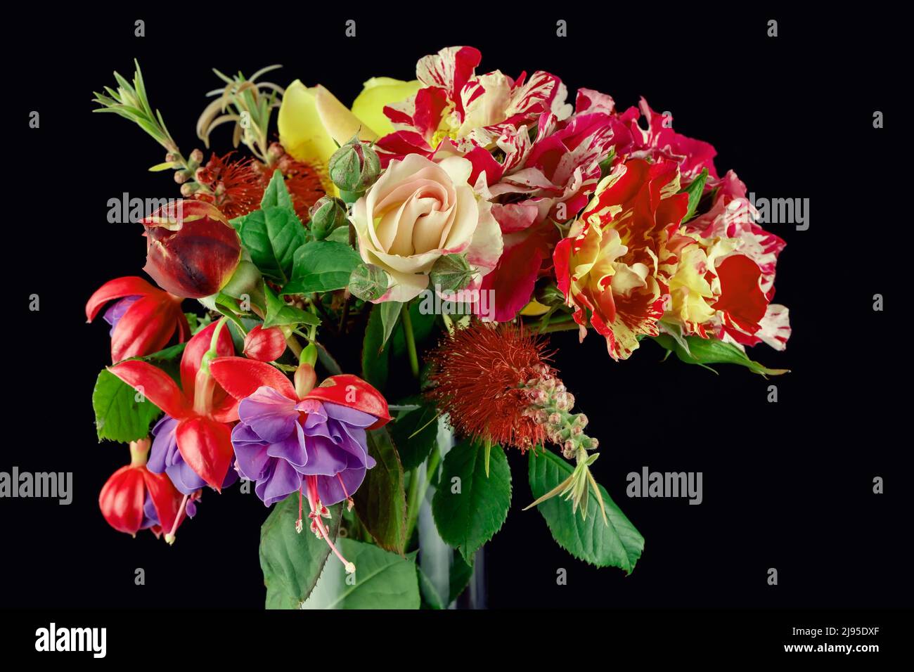 Ein Bouquet von verschiedenen farbigen Blumen in einer Glasvase isoliert auf schwarzem Hintergrund Stockfoto