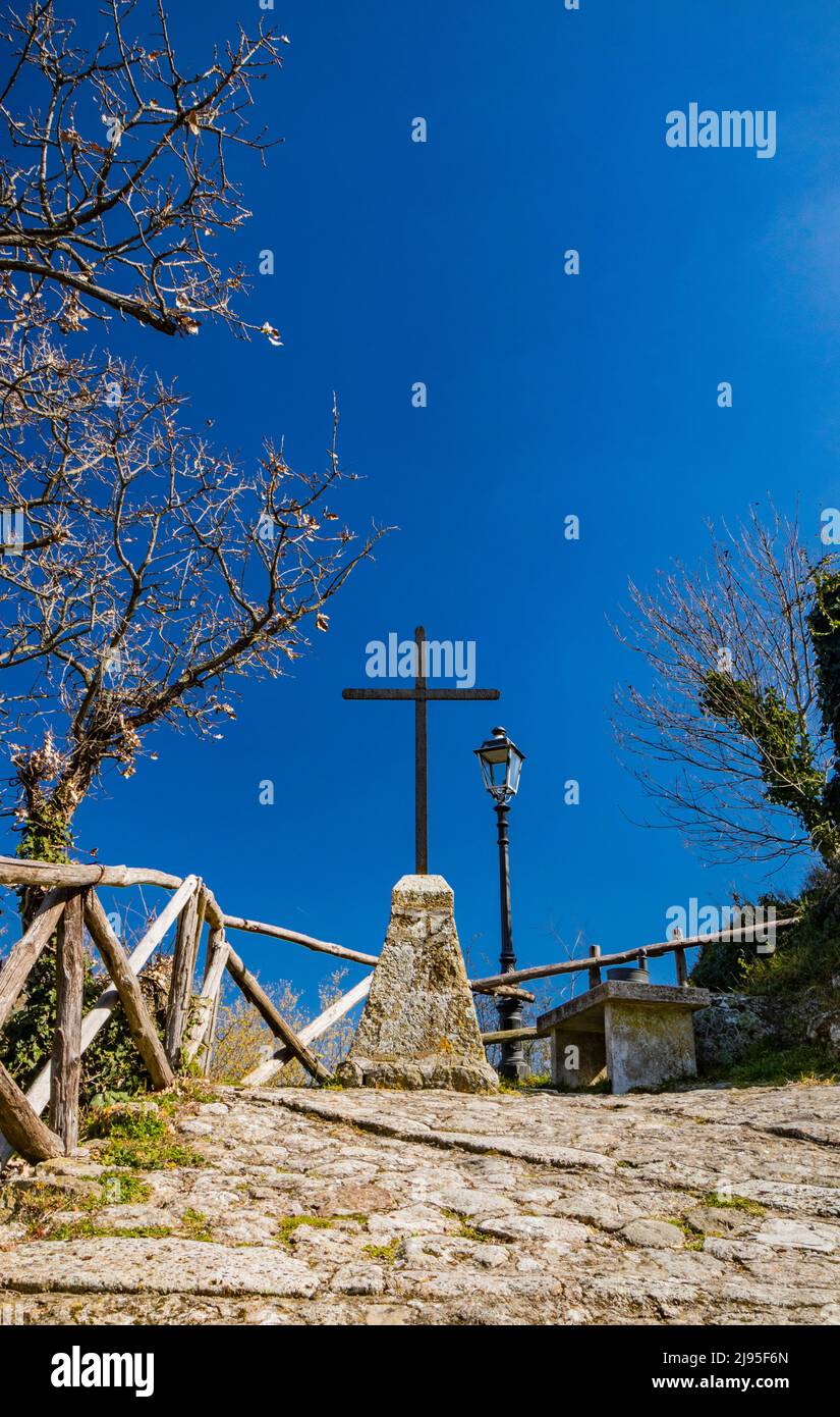 Das kleine Dorf Tolfa, in Latium. Die gepflasterte Gasse, die steil zum Heiligtum der Madonna della Rocca hinaufsteigt. Die Route ist durch Th gekennzeichnet Stockfoto