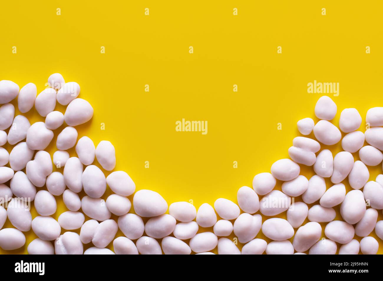 Flay Lay von geschälten Pinienkernen auf gelbem Hintergrund Stockfoto