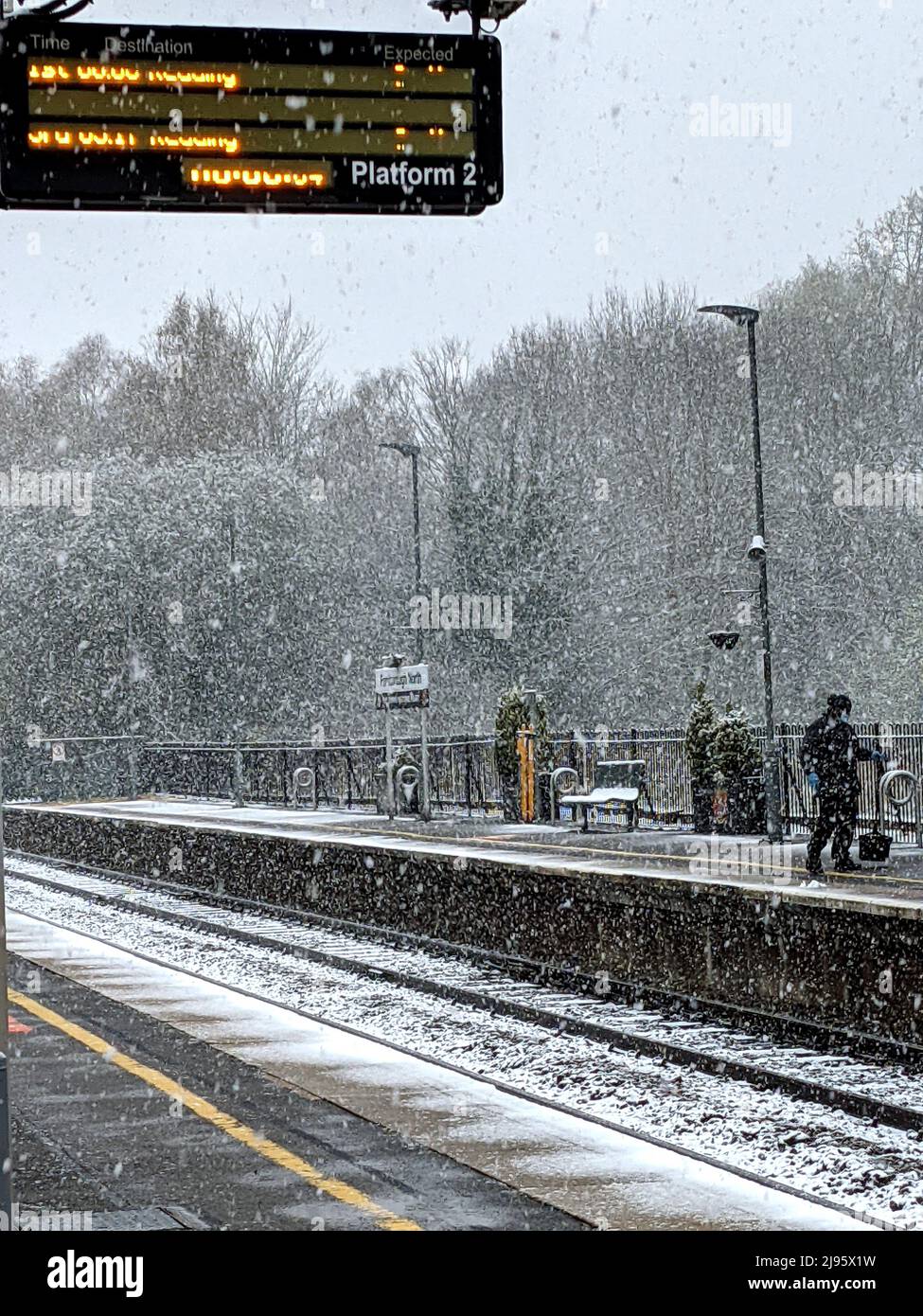 Warten auf einen Zug am Bahnhof im Schnee, der Zug kommt zu spät Stockfoto