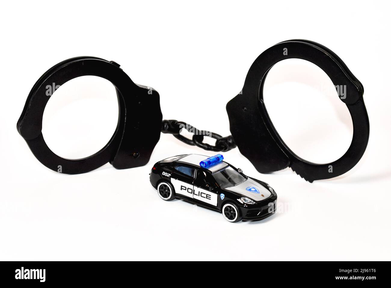 Handschellen mit Spielzeug Polizeiauto Stockfoto