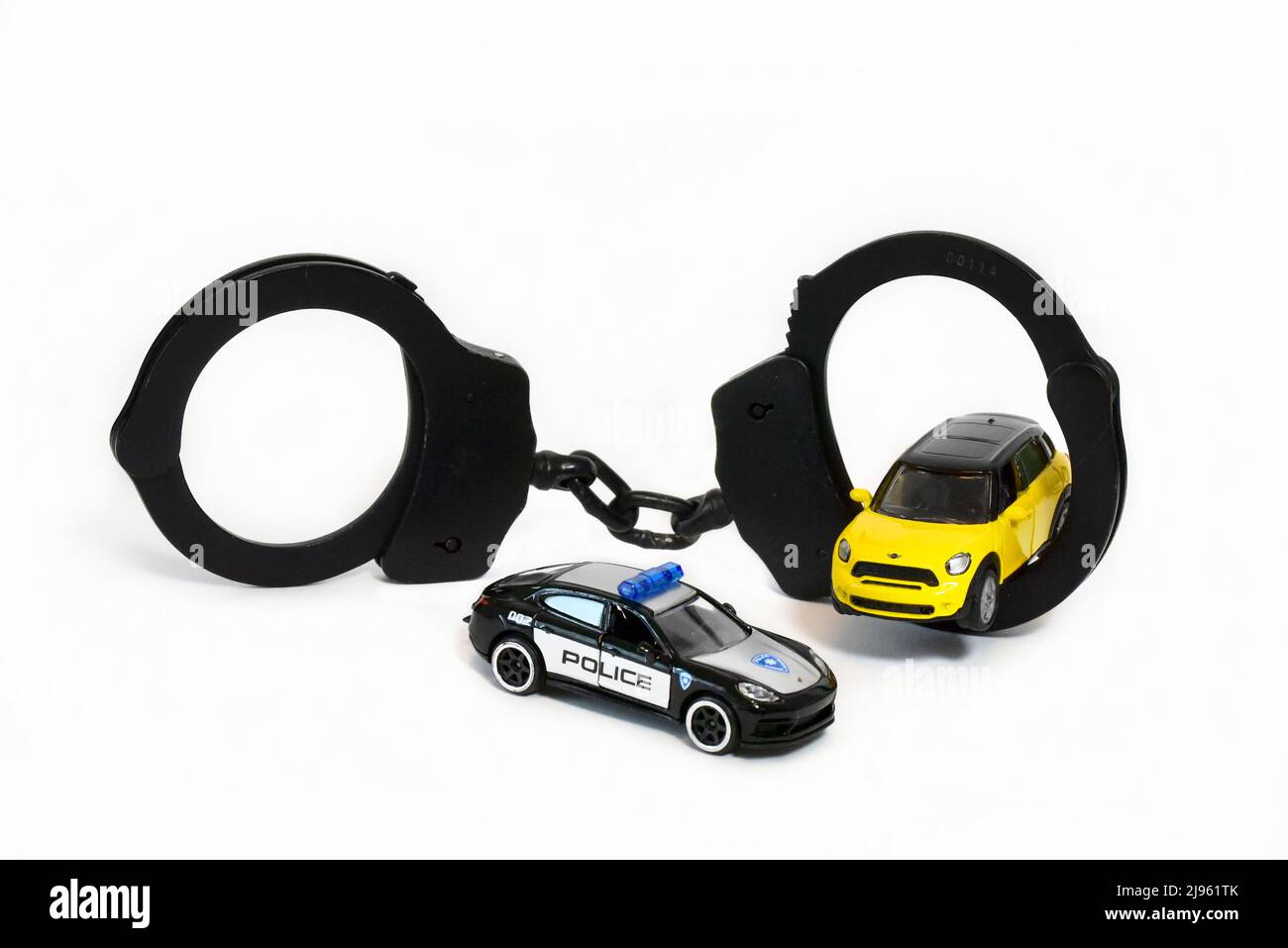 Handschellen mit Polizei-Spielzeugauto Stockfoto