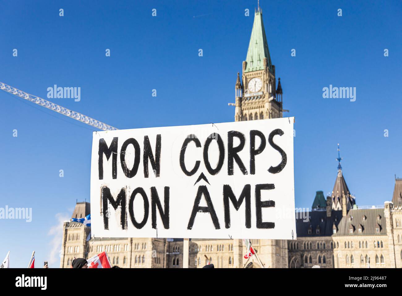 Nahaufnahme selektive Fokusansicht eines französisch-kanadischen Plakat, das meinen Körper während einer Antivax-Kundgebung mit verschwommenen parlamentsgebäuden im Hintergrund als meine Seele ausgibt. Stockfoto