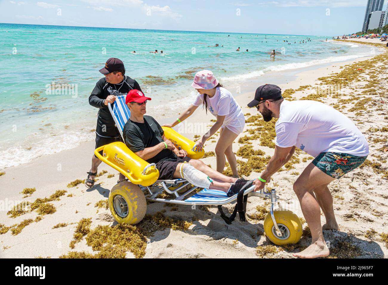 Miami Beach Florida, Sabrina Cohen Adaptive Beach Day, Behinderte spezielle Bedürfnisse Behinderte Wasserräder schwimmenden Rollstuhl, hispanischer Mann männlich weiblich Frau Stockfoto