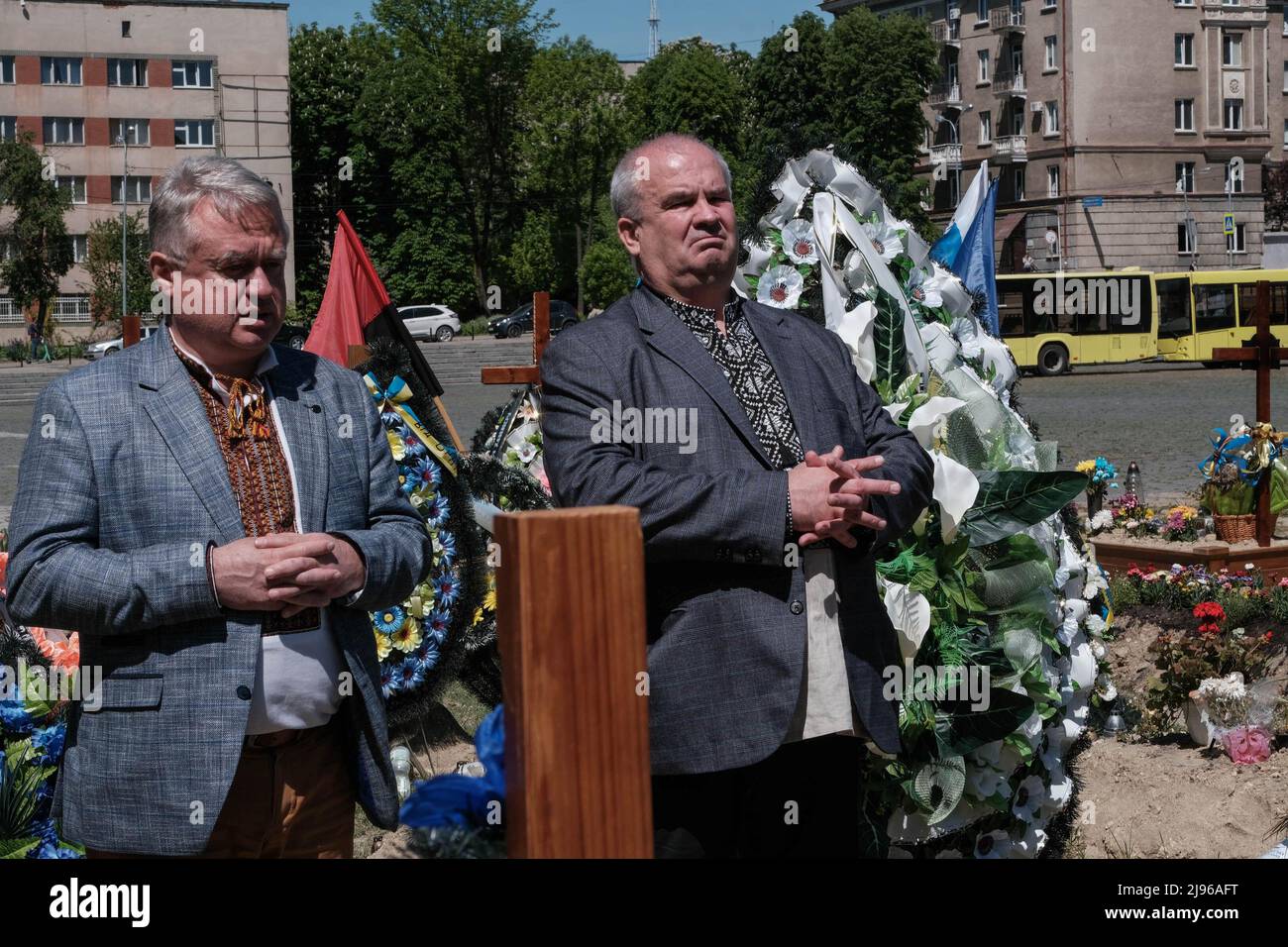 Lviv, Ukraine. 19.. Mai 2022. Zwei Trauersoldaten mit traditionellen ukrainischen Wyschywankas (bestickte Hemden) stehen am Grab des ukrainischen Soldaten Bogdan Wolodymyrowytsch, der von russischen Truppen in der Nähe von Dryzba in der Region Luhansk auf dem Lytschakiv-Friedhof getötet wurde. (Bild: © Joe M O'Brien/SOPA Images via ZUMA Press Wire) Stockfoto