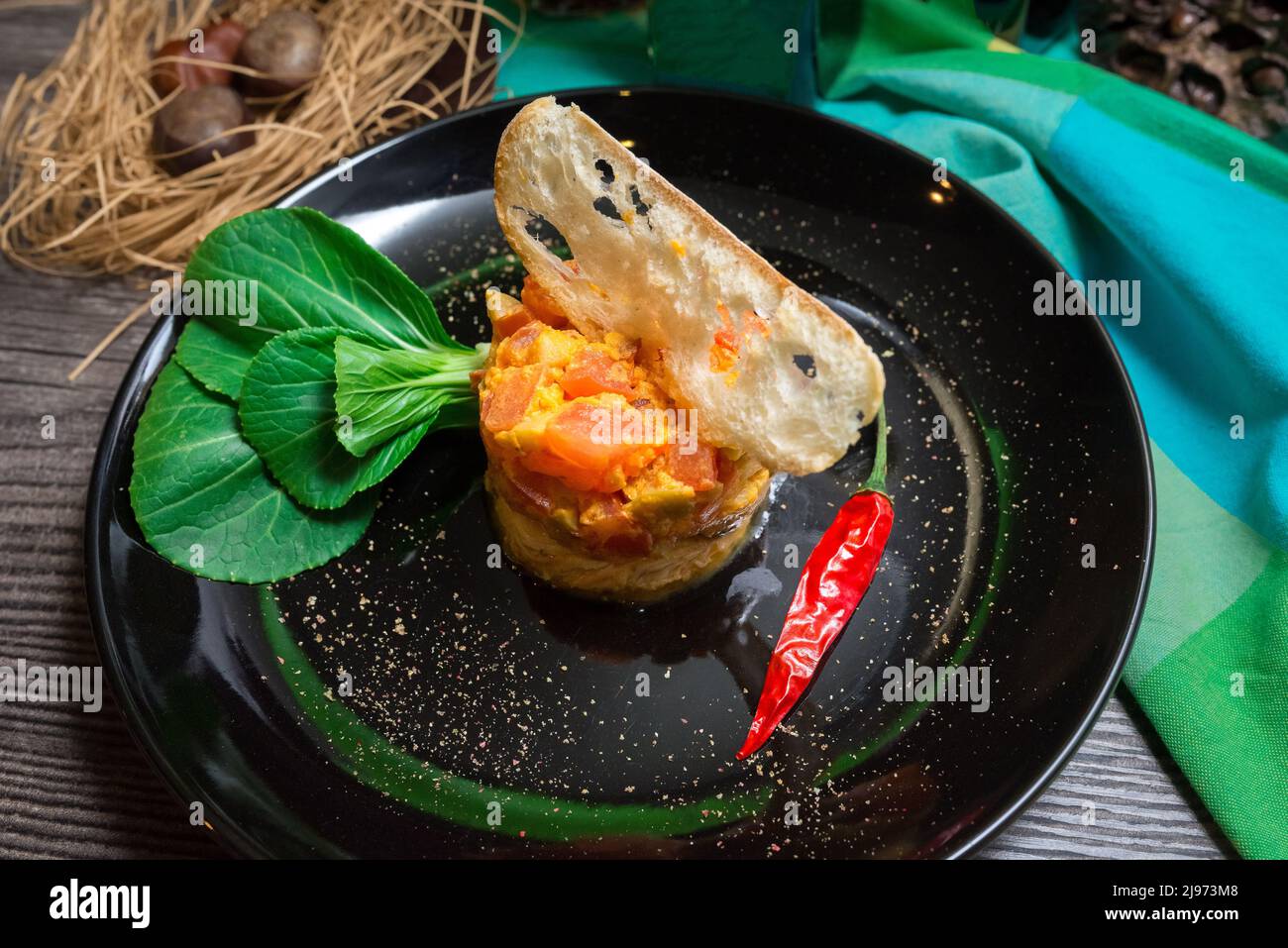 Hühnerschnitzel mit würziger Tomate und Oliven-Geschmack. Dekoriert mit einer schmalen Scheibe Crouton, Chili an einer Seite, frischen jungen pak Choi. Salat klingelt uns Stockfoto