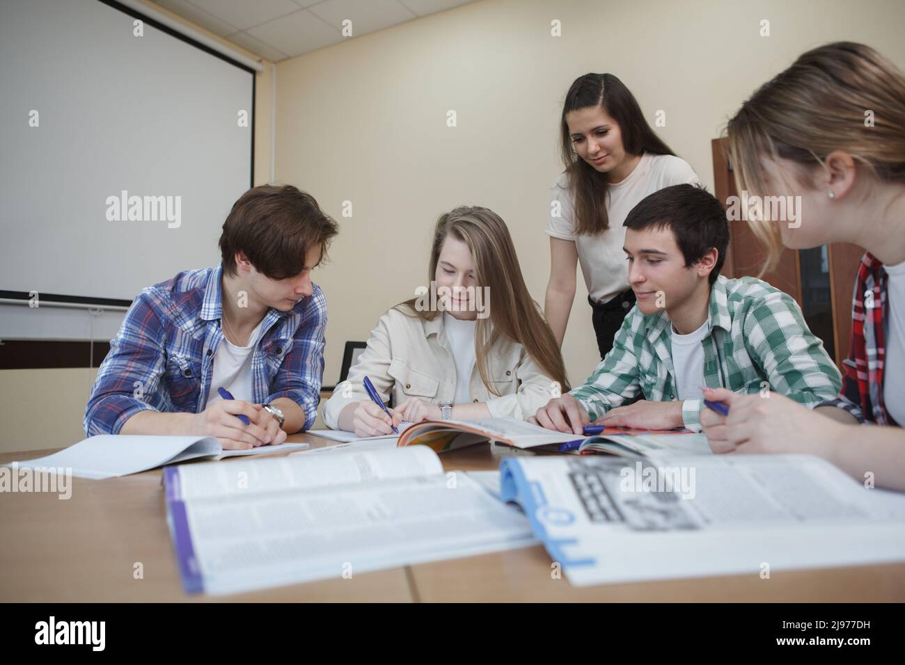 Junge Menschen, die gemeinsam im College-Klassenzimmer studieren Stockfoto