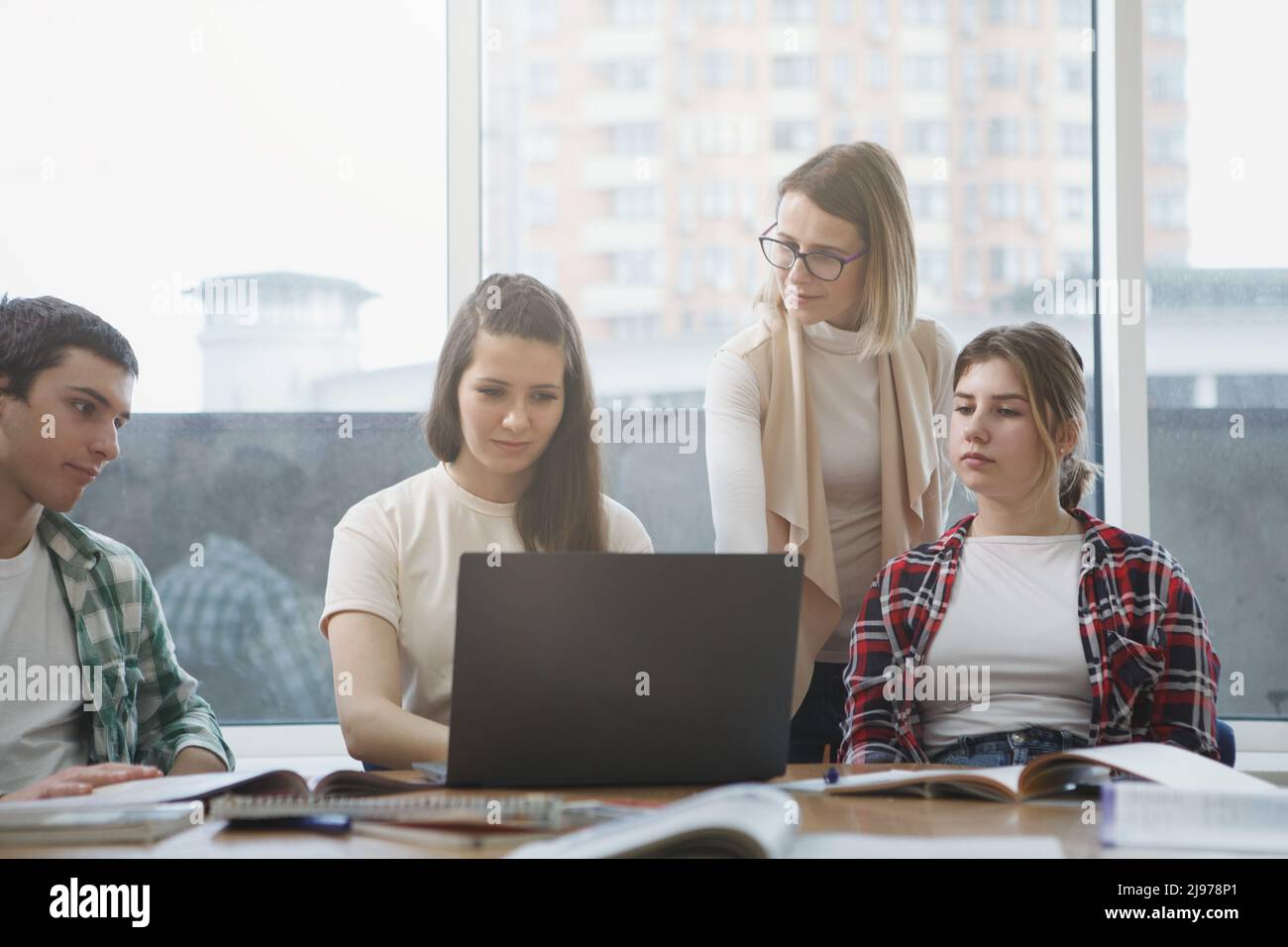 Reife Lehrerin hilft ihren Schülern während des Seminars Stockfoto