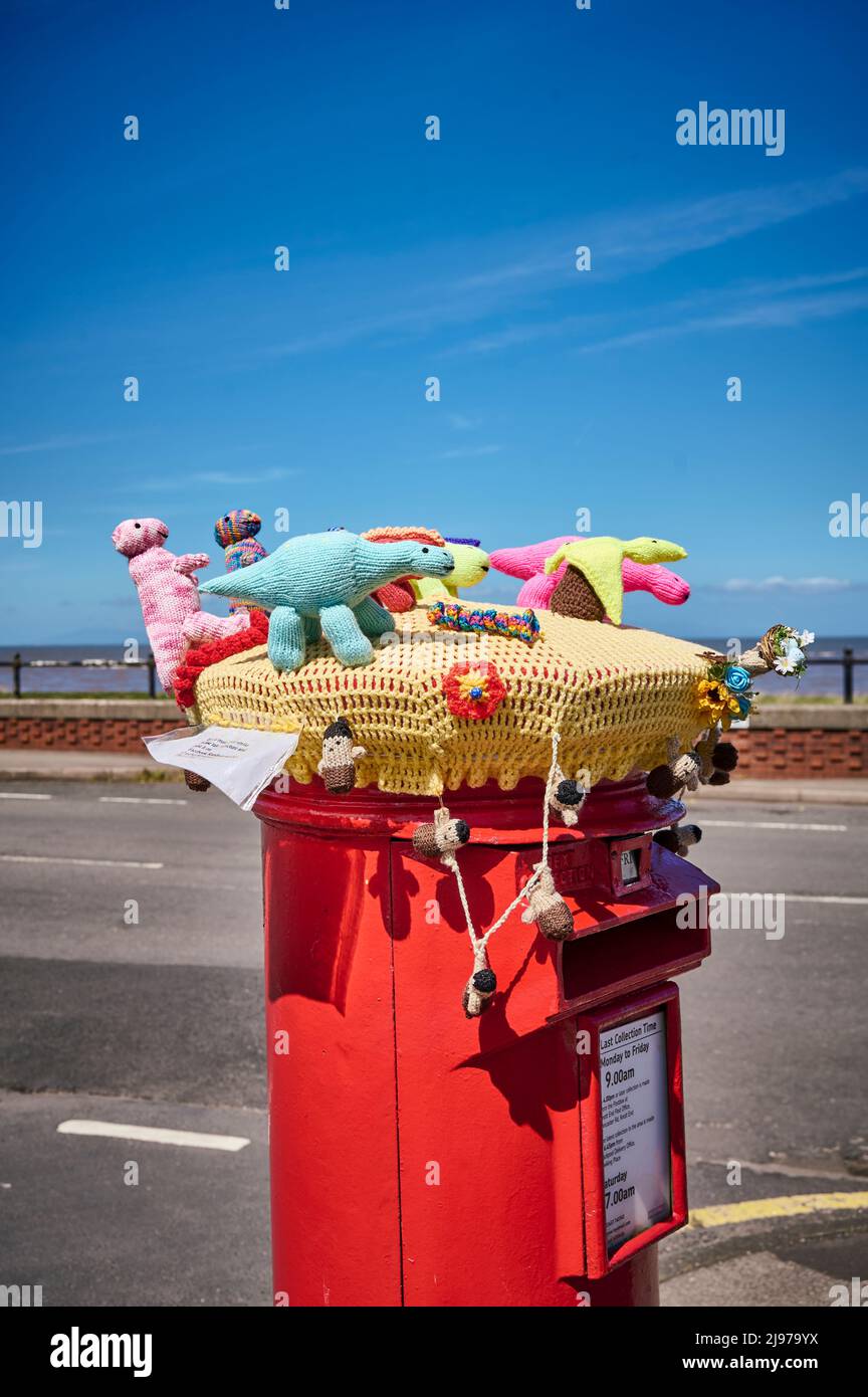 An der Straße befindet sich ein Briefkasten, der von gestrickten Spielzeugtieren gekrönt wird Stockfoto