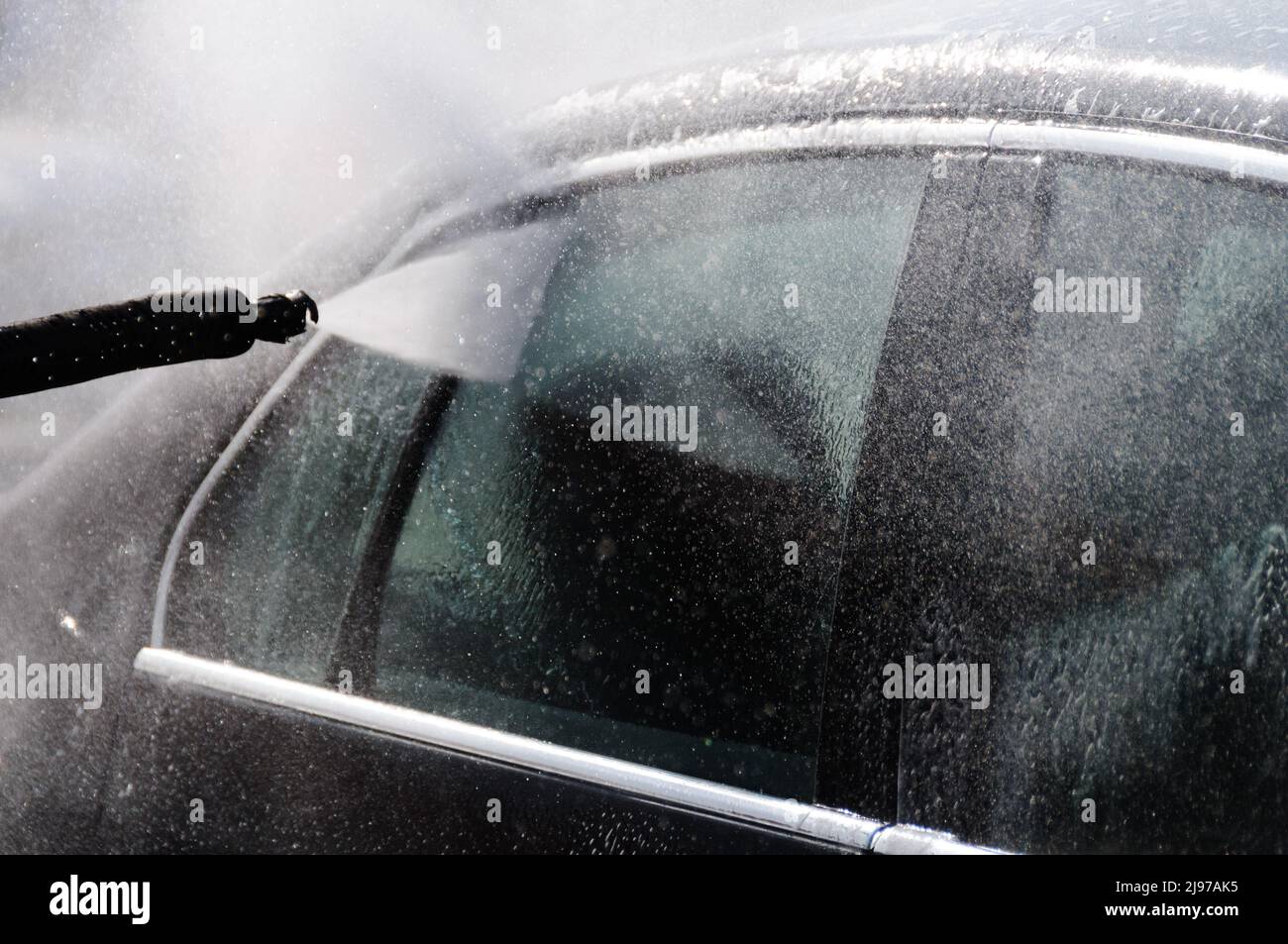 Ein Auto, das mit einem Hochdruckreiniger gewaschen wird Stockfoto