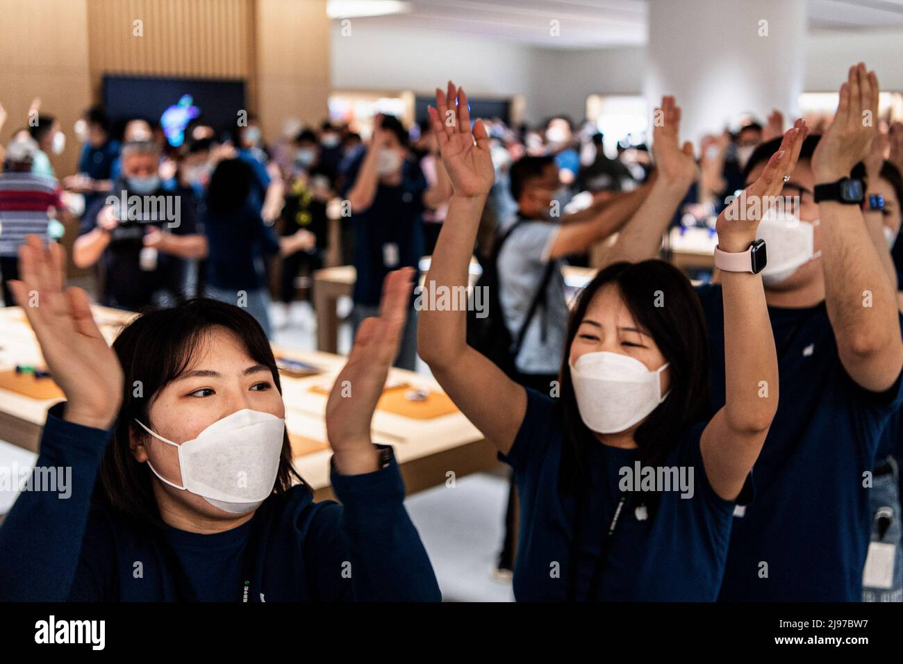 Wuhan, China. 21.. Mai 2022. Maskierte Apple-Mitarbeiter begrüßen Kunden bei der Eröffnung eines neuen Stores in Wuhan, der chinesischen Provinz Hubei. Apple eröffnete seinen ersten Flagship-Store in Wuhan, ebenfalls den 54. Flagship-Store im Großraum China. Kredit: SOPA Images Limited/Alamy Live Nachrichten Stockfoto