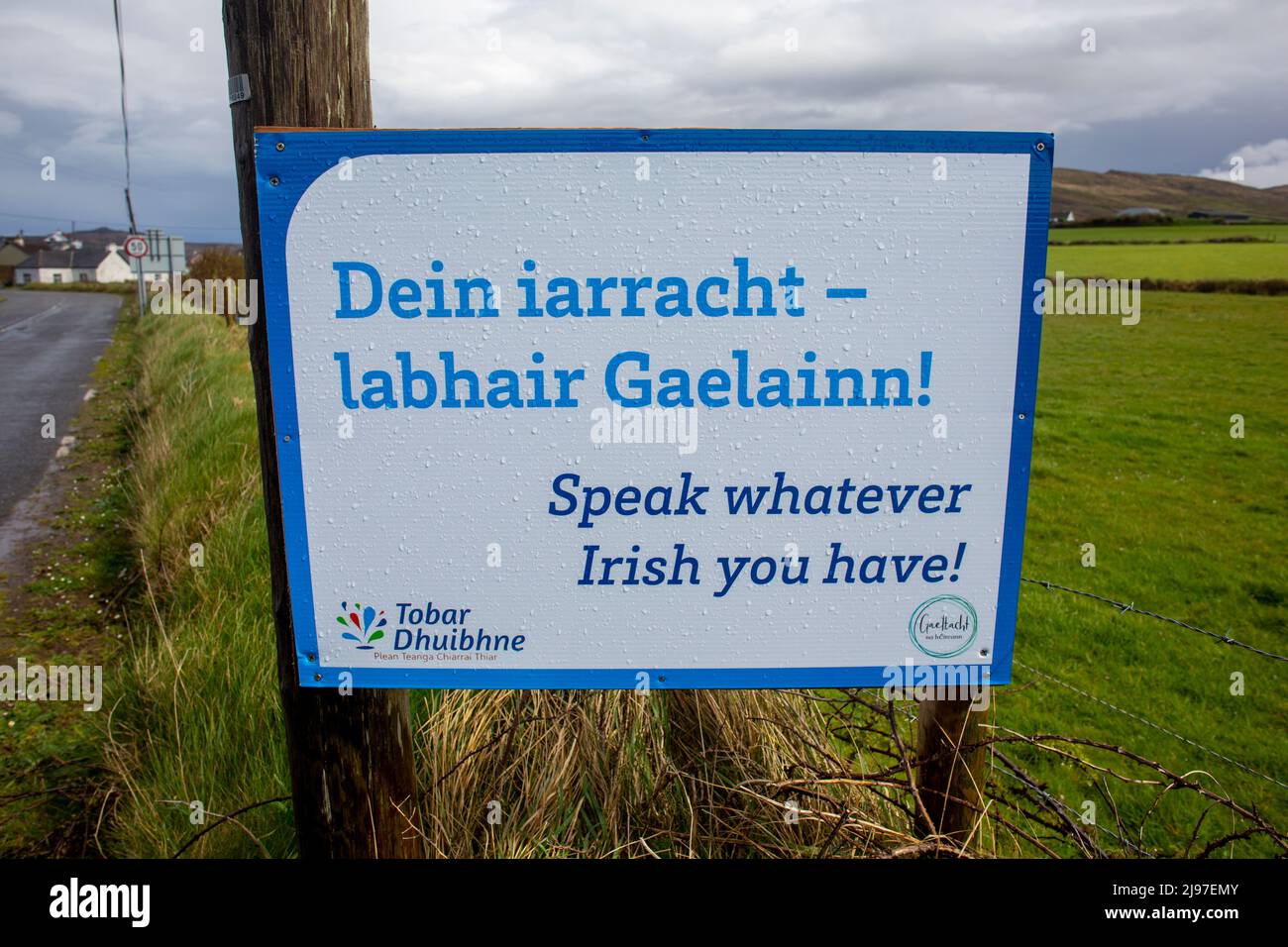 Ein Straßenschild auf der Halbinsel Dingle in zwei Sprachen, Irisch (Gälisch) und Englisch.das Gebiet ist zweisprachig und Teil der Gaeltacht. Stockfoto