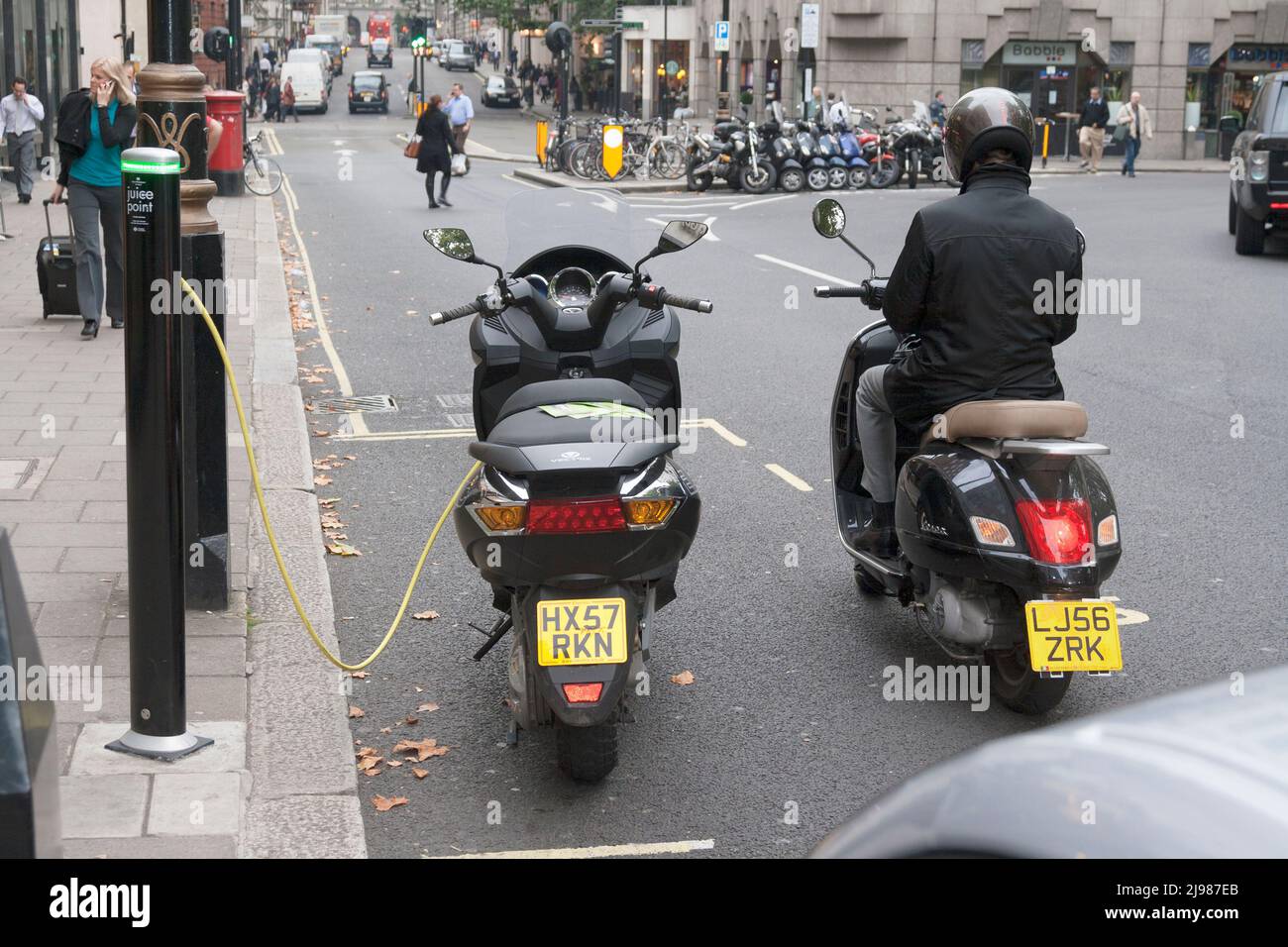Autofahrer, der darauf wartet, seinen Roller aufzuladen, London, Großbritannien Stockfoto