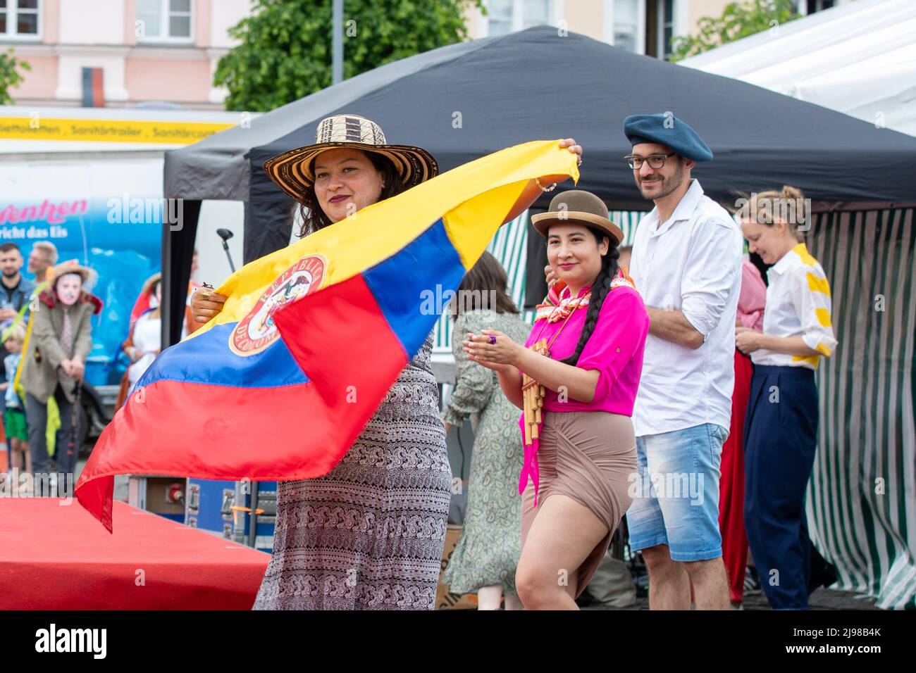 Ostritz, Deutschland. 21.. Mai 2022. Eine Frau tanzt mit einem Hut auf dem Kopf und hält die Flagge Ecuadors an der Modenschau, die das Thema Demokratie, Kosmopolitismus und Toleranz hat. Das Friedensfestival ist seit Jahren ein integraler Bestandteil der Gemeinschaft, um sich gegen rechtsorientierte Veranstaltungen in der Stadt zu wehren. Quelle: Daniel Schäfer/dpa/Alamy Live News Stockfoto