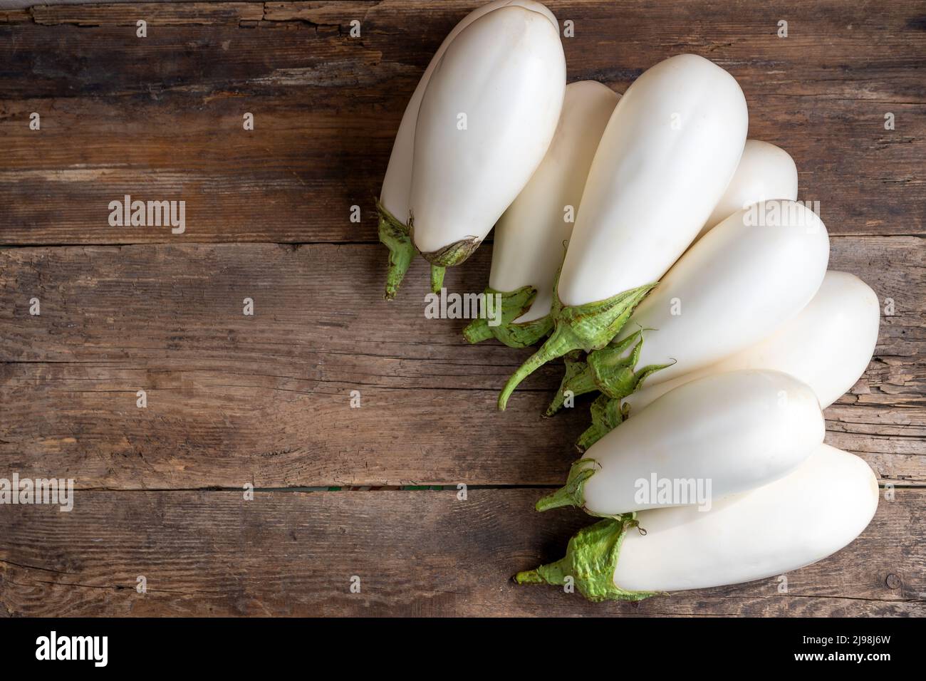 Ernte weiße Auberginen auf einem hölzernen Hintergrund mit Platz für Text. Auberginen Gemüse auf dem Tisch. Lebensmittel mit Kopierplatz. Stockfoto