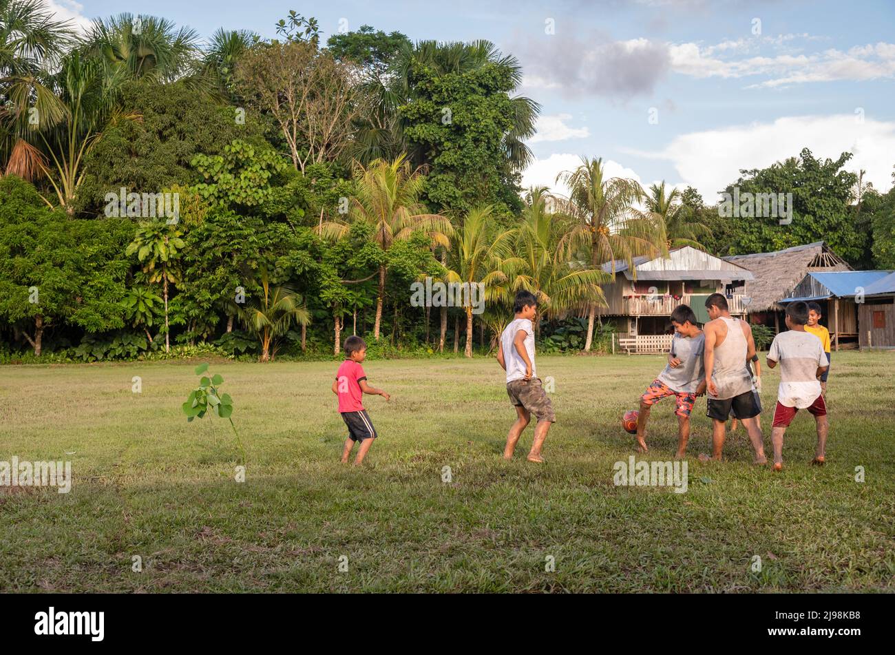 Jungen, die in einer lokalen Gemeinde in Peru im Amazonasgebiet Fußball spielen Stockfoto