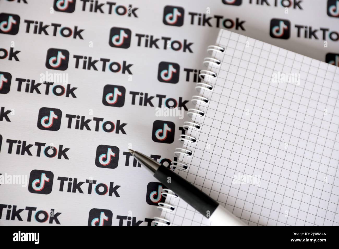 TERNOPIL, UKRAINE - 2. MAI 2022: Notizblock mit Stift und vielen TikTok-Logos auf Papier gedruckt. TikTok oder Douyin ist ein berühmtes chinesisches Kurzform-Video-Hosting Stockfoto