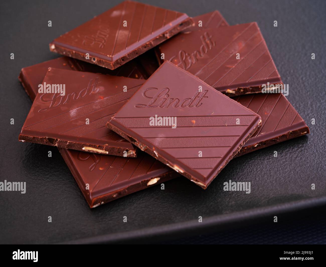 Tambow, Russische Föderation - 29. März 2022 Stücke Lindt Schokolade auf schwarzem Teller. Nahaufnahme Stockfoto