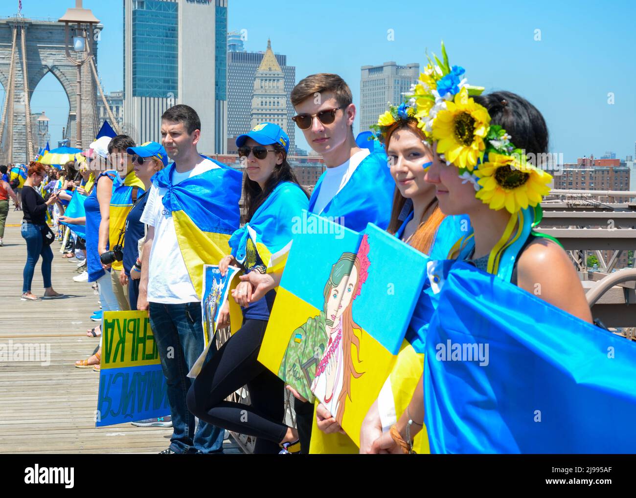 Am 21. Mai 2022 werden Teilnehmer der Menschenkette mit ukrainischer Flagge auf der Brooklyn Bridge, New York City, gesehen. Stockfoto