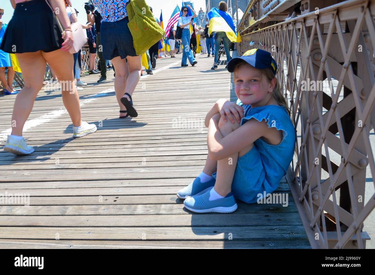 Am 21. Mai 2022 wird ein junger Teilnehmer der Menschenkette mit einer ukrainischen Flagge auf der Brooklyn Bridge, New York City, gesehen. Stockfoto