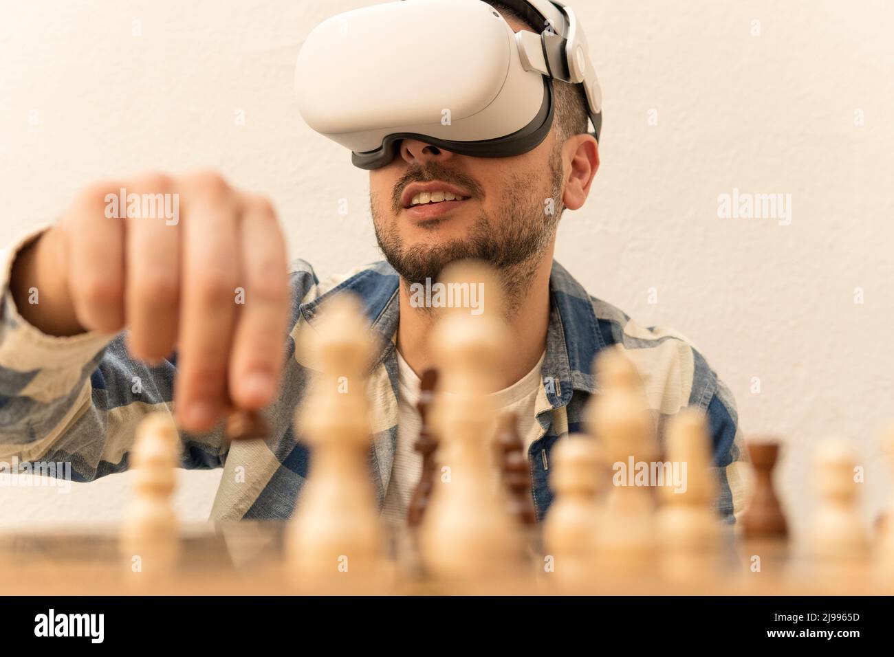 Mann, der Schach bewegt, spielt online auf seiner Virtual-Reality-Brille Stockfoto
