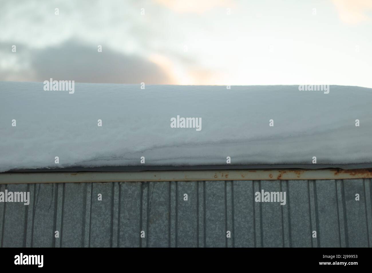 Schnee auf dem Dach. Große Schneeschicht auf dem Haus. Details zum Winterwetter. Stockfoto