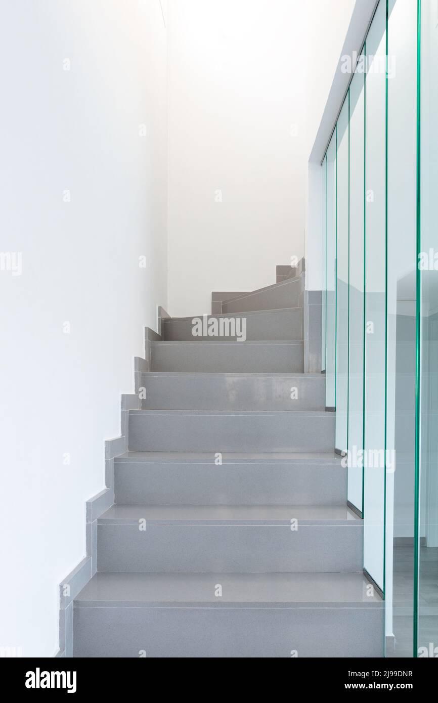 Eine moderne Treppe. Marmortreppe und Glasgeländer. Stockfoto