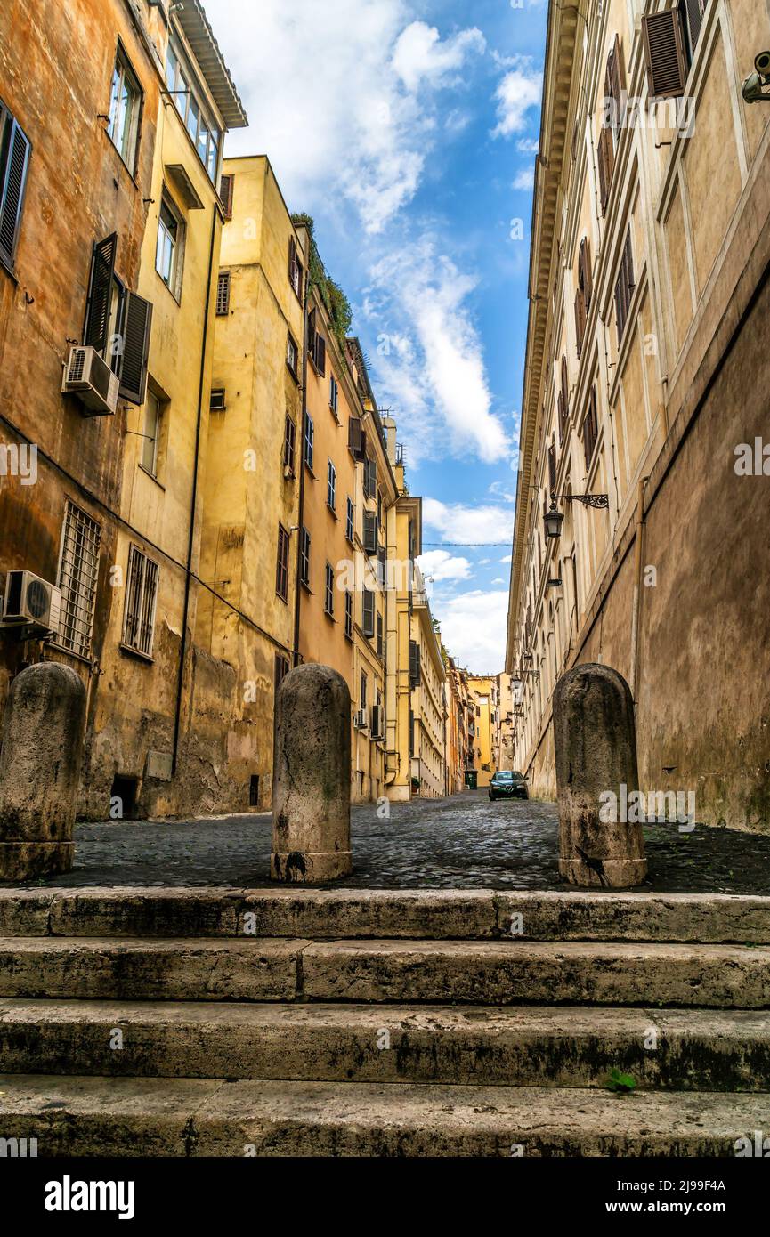 Enge Straße mit Treppen, Rom, Italien. Vertikale Vintage-Ansicht von Treppen und schäbigen Wohngebäuden in Rom. Antike Häuser in der alten Straße mit dea Stockfoto