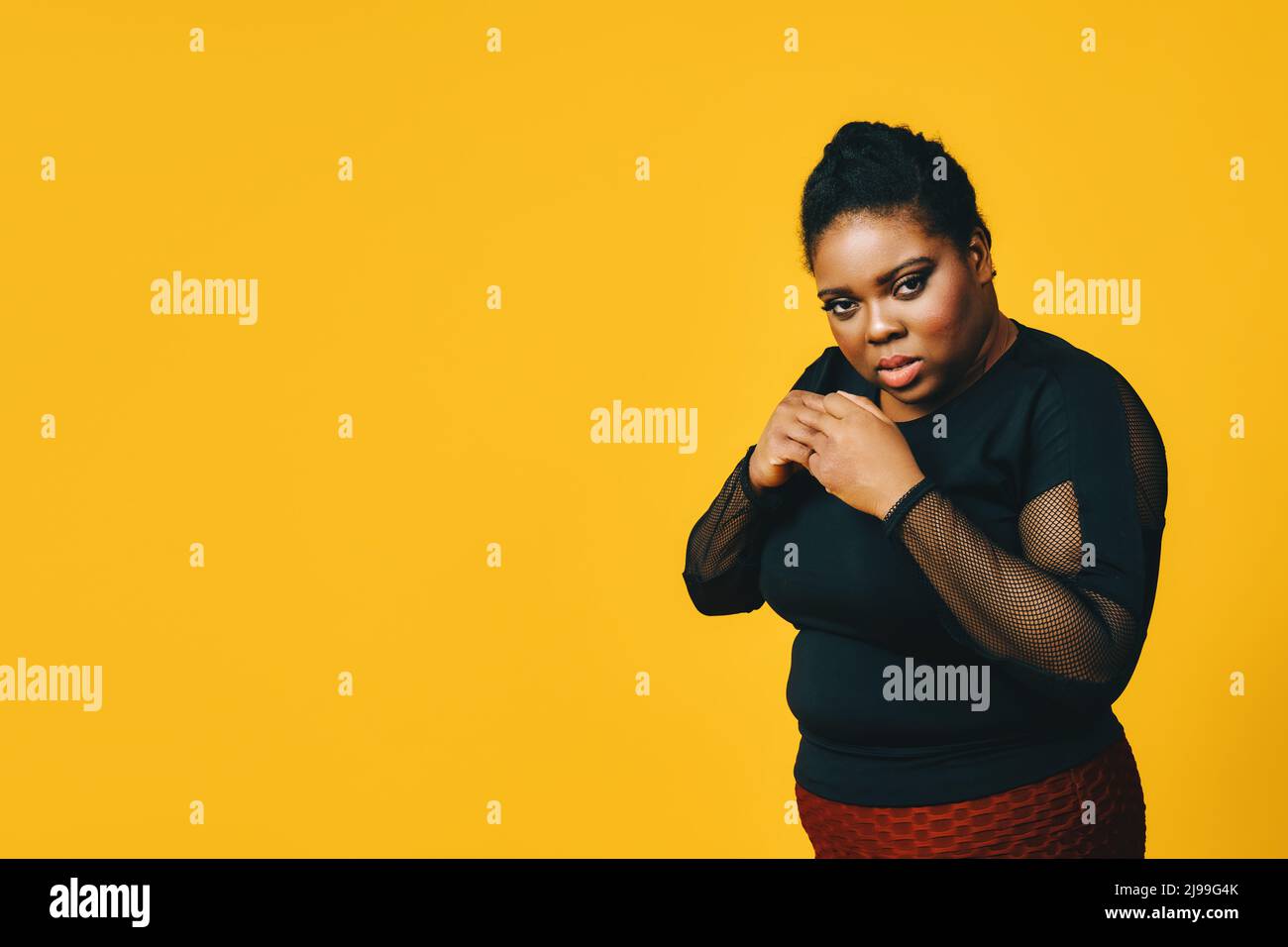 Porträt der schwarzen Frau mit Armen in Kampfposition auf gelbem Hintergrund Studio Stockfoto