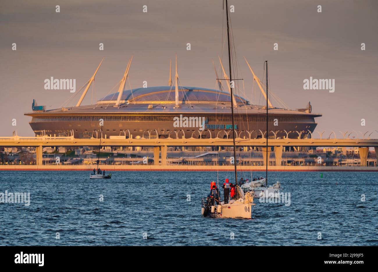 Russland, St. Petersburg, 20. Mai 2022: Segelboote im Hintergrund des neuen Stadions Gazprom Arena von der Ölgesellschaft Gazprom im Abendlicht Stockfoto