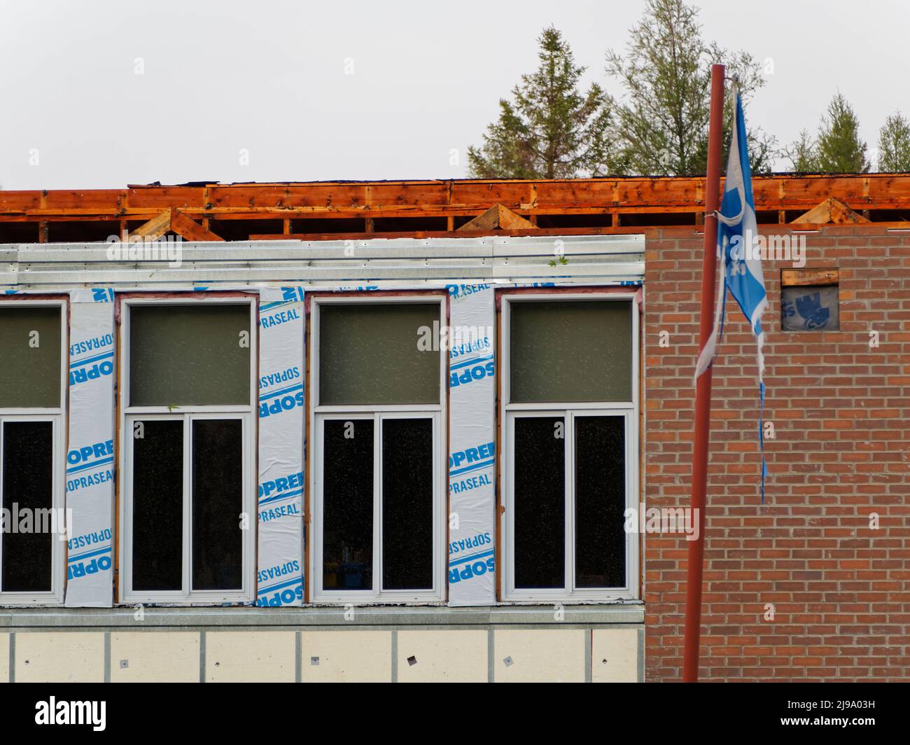 Starker Wind am späten Samstagnachmittag reißt das Dach einer Grundschule, die gerade renoviert wird, in Saint-Alphonse-Rodriquez, Quebec, Kanada Stockfoto