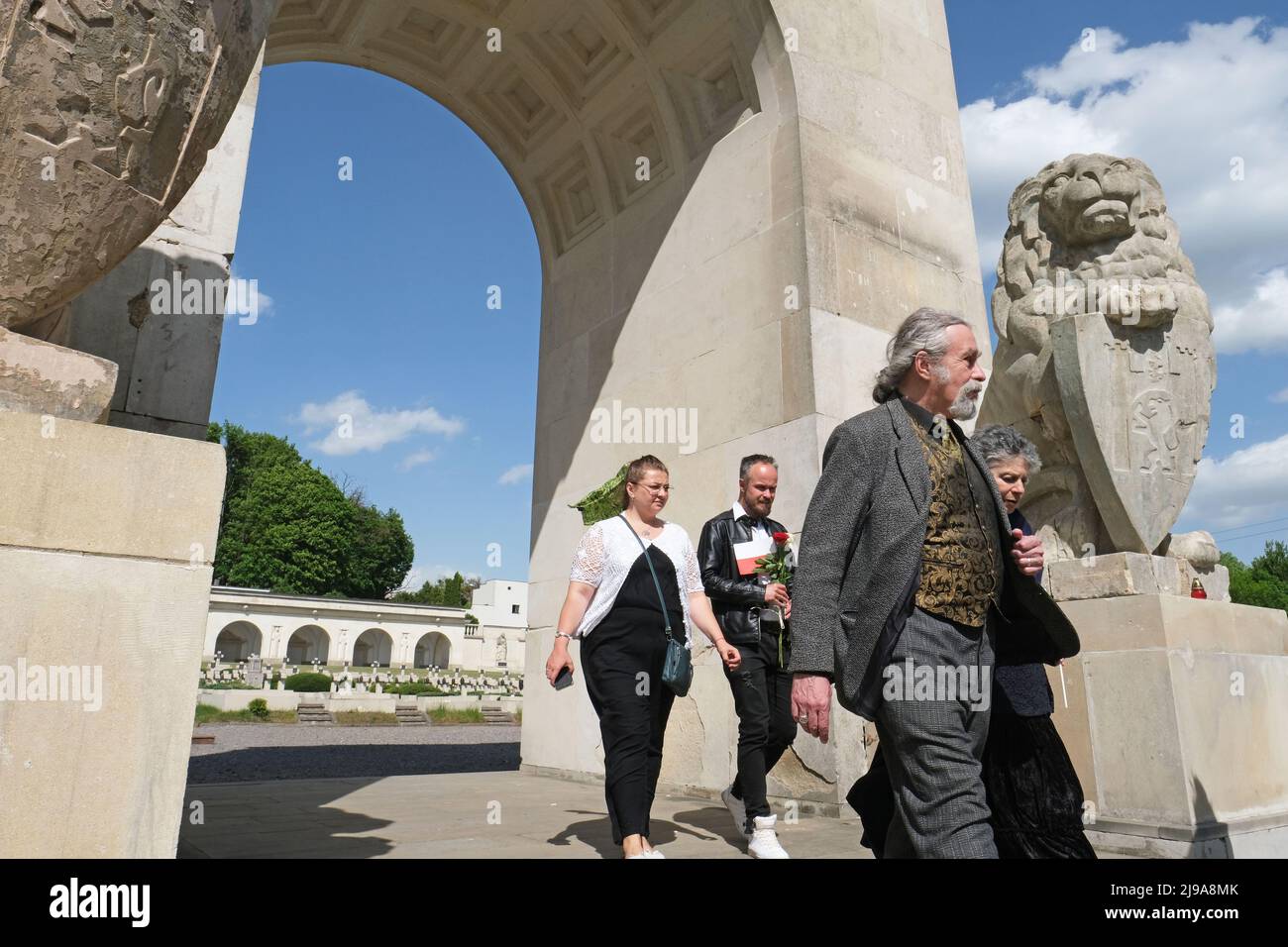 Lviv, Ukraine. 21.. Mai 2022. Auf dem „Adlerfriedhof“ (Polnischer Friedhof) auf dem Lychakiv-Friedhof in Lemberg zollen die Menschen ihren Respekt. Zwei Löwenstatuen stehen auf beiden Seiten des 'Glory Monument'. Die Statuen waren zuvor bedeckt und wurden am 20.. Mai 2022 enthüllt. Die Statuen wurden von den sowjetischen Behörden in den 1970er Jahren entfernt und erst 2015 zurückgegeben, aber bedeckt. Die meisten Menschen, die auf dem Friedhof begraben wurden, starben während des ukrainisch-polnischen Krieges 1918-1920. Kredit: SOPA Images Limited/Alamy Live Nachrichten Stockfoto