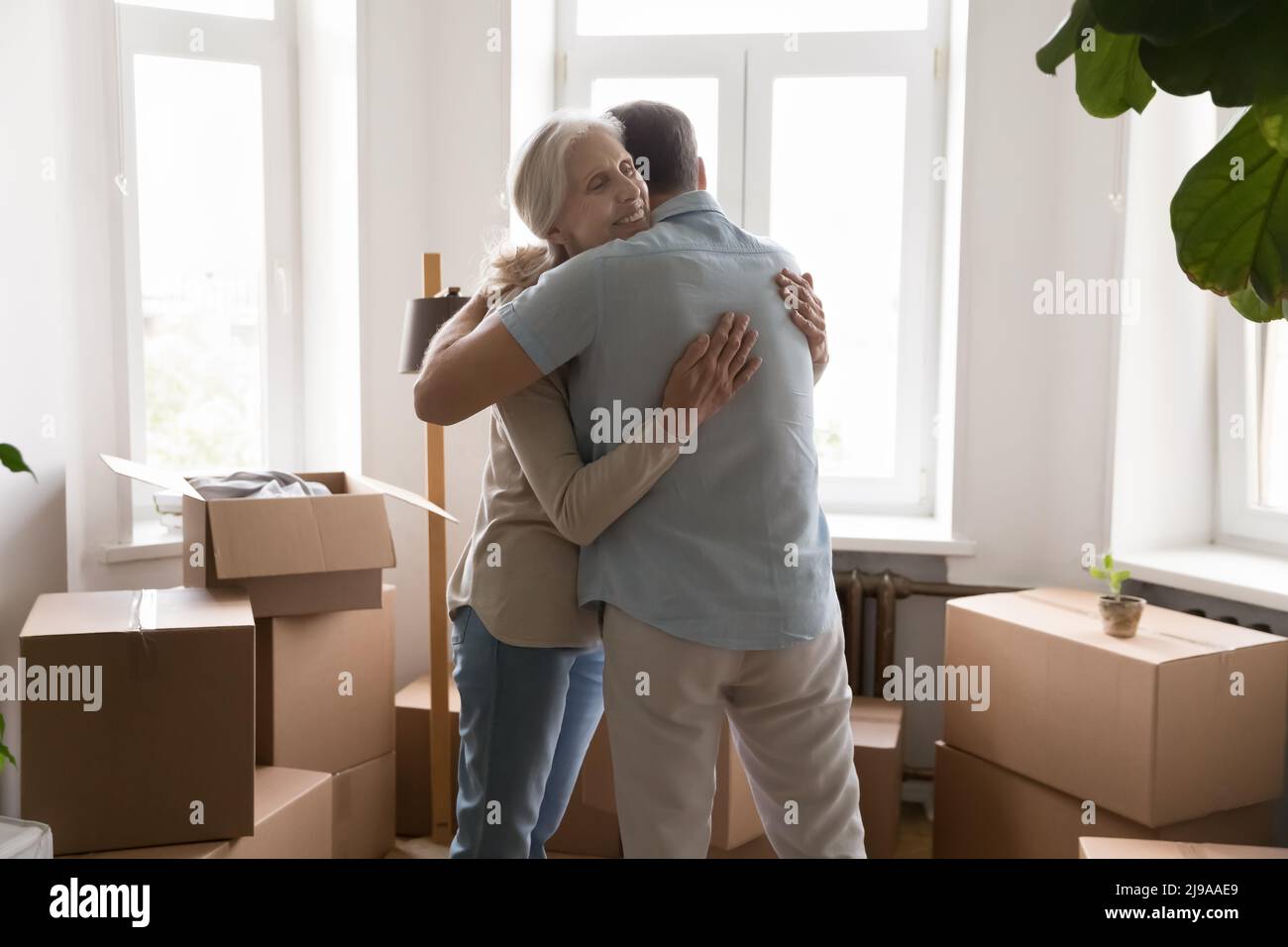 Glückliche, dankbare ältere Frau, die den Ehemann mit Liebe umarmt Stockfoto