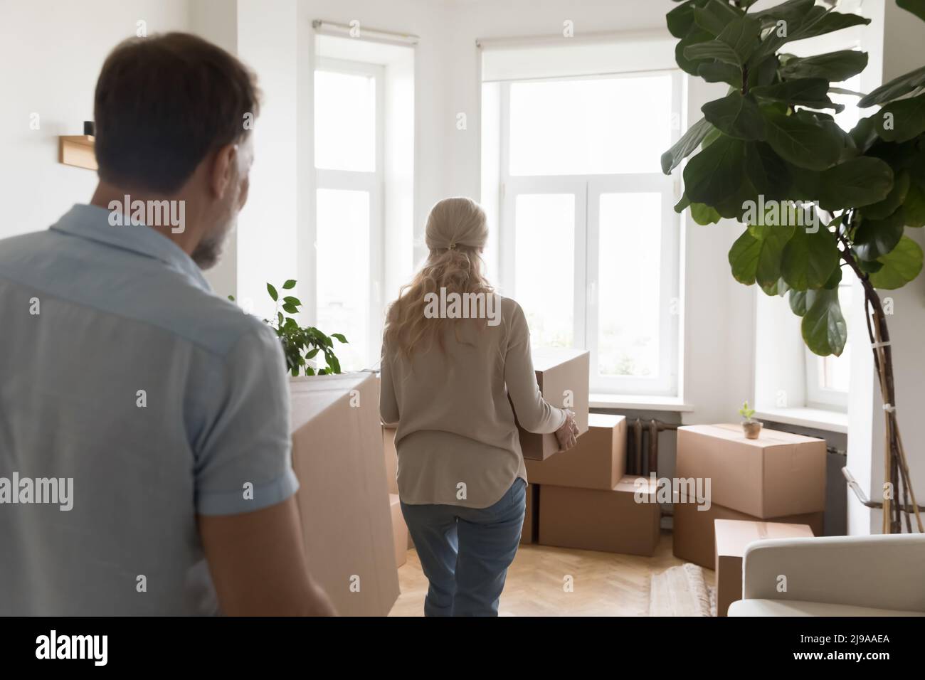 Reifes Paar zieht in eine neue Wohnung und trägt Pappkartons Stockfoto